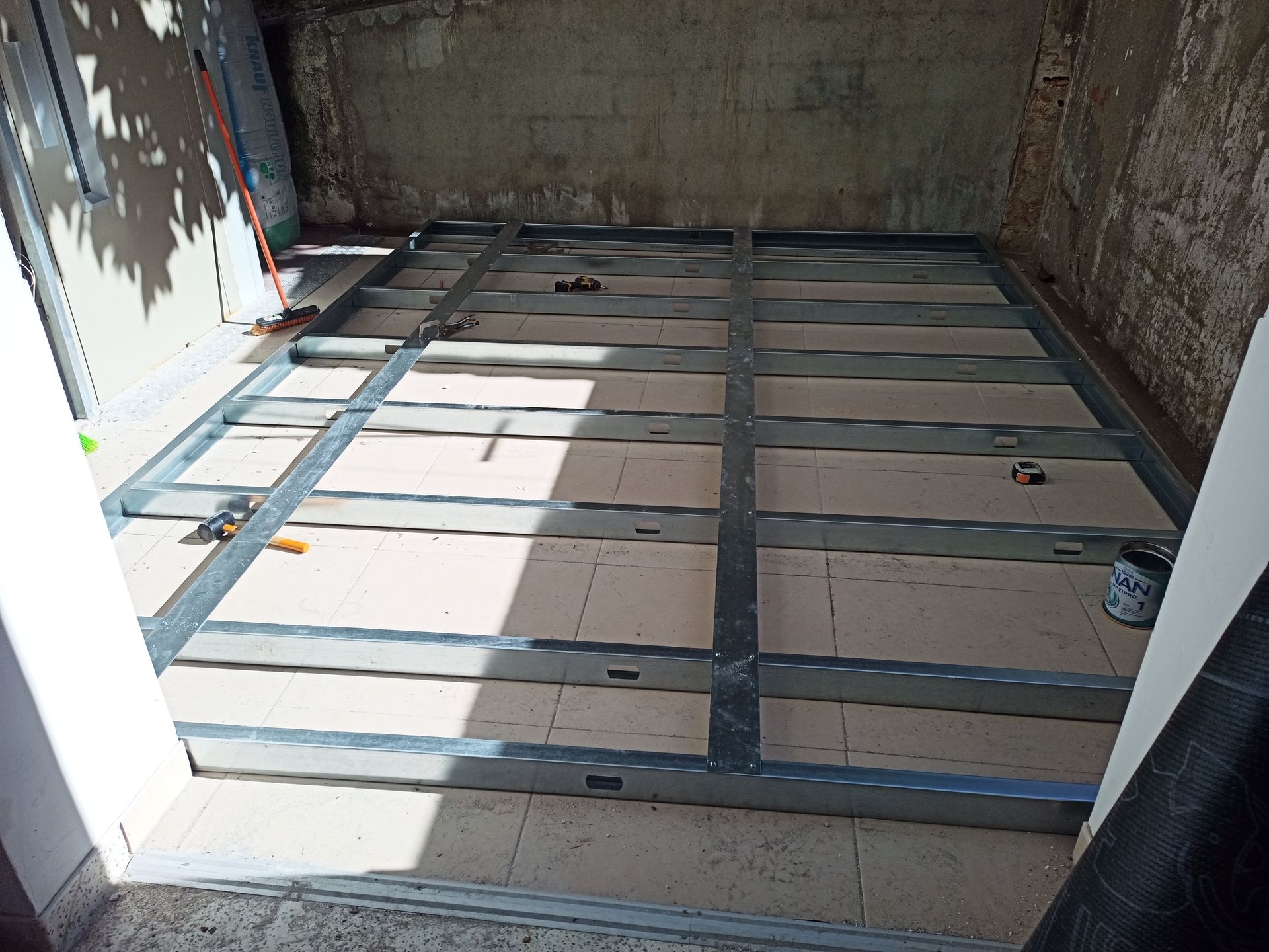 Estrutura metálica sobre piso de azulejo, em um ambiente com paredes de cor clara.