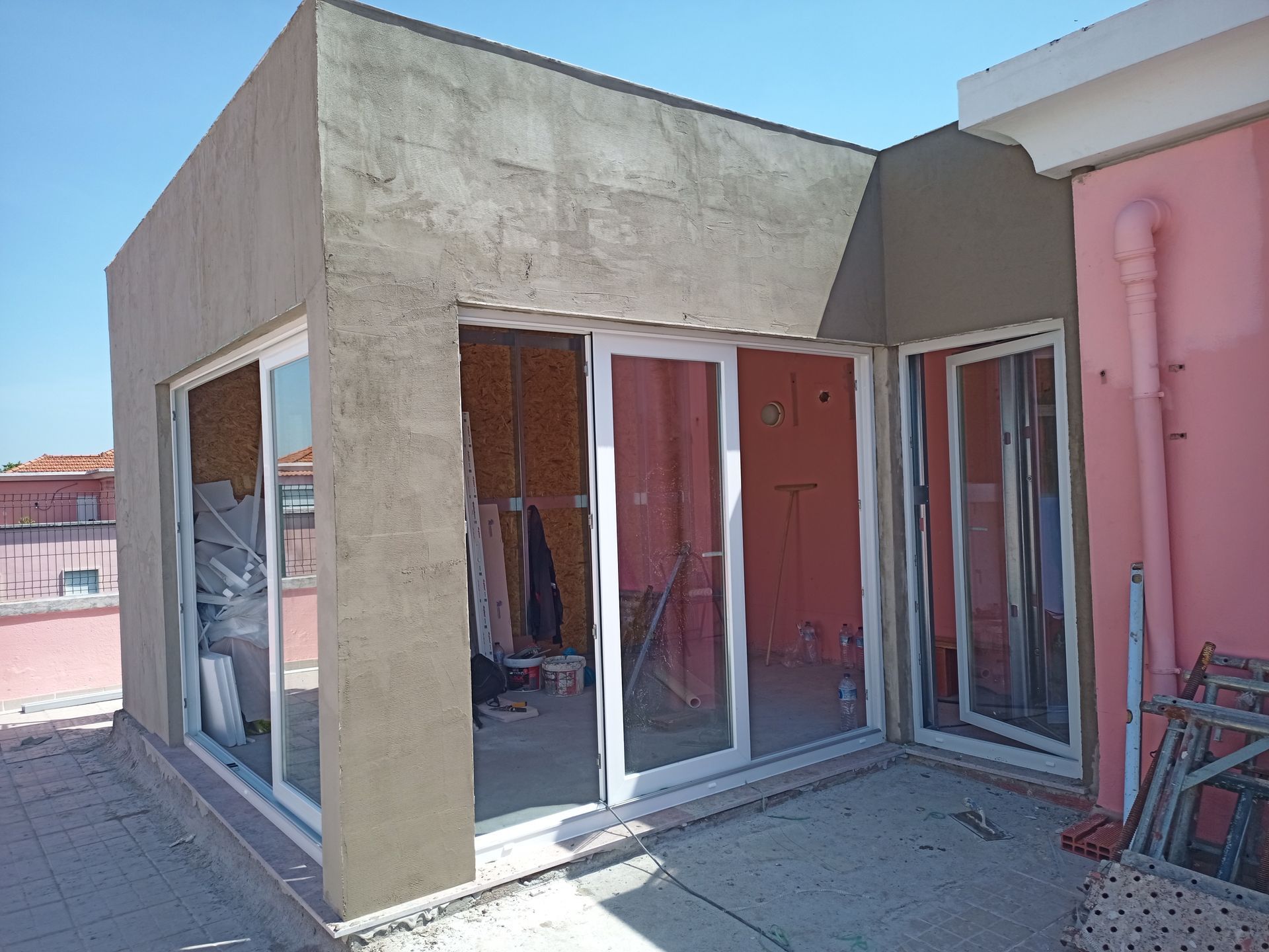 Prédio com portas de correr de vidro em construção; vista exterior.