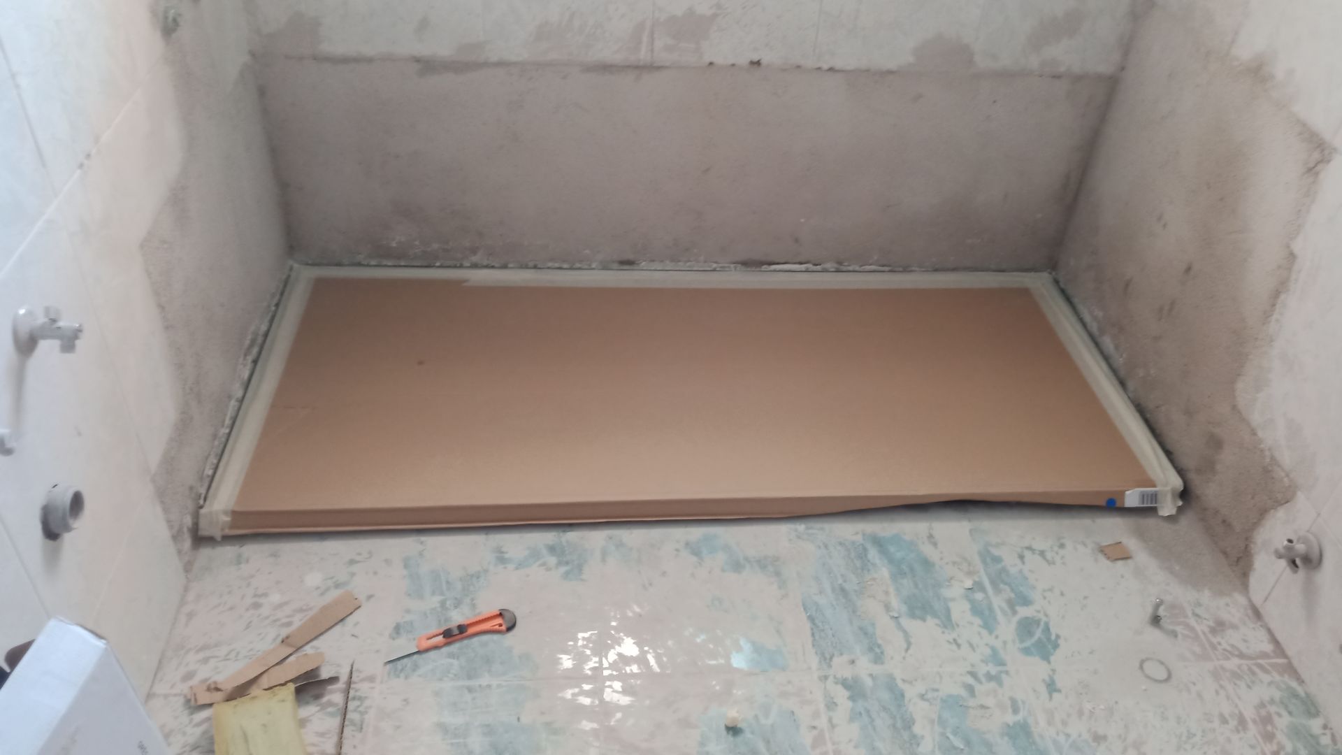 Cabina de duche com cartão no interior, pronta para receber azulejos.