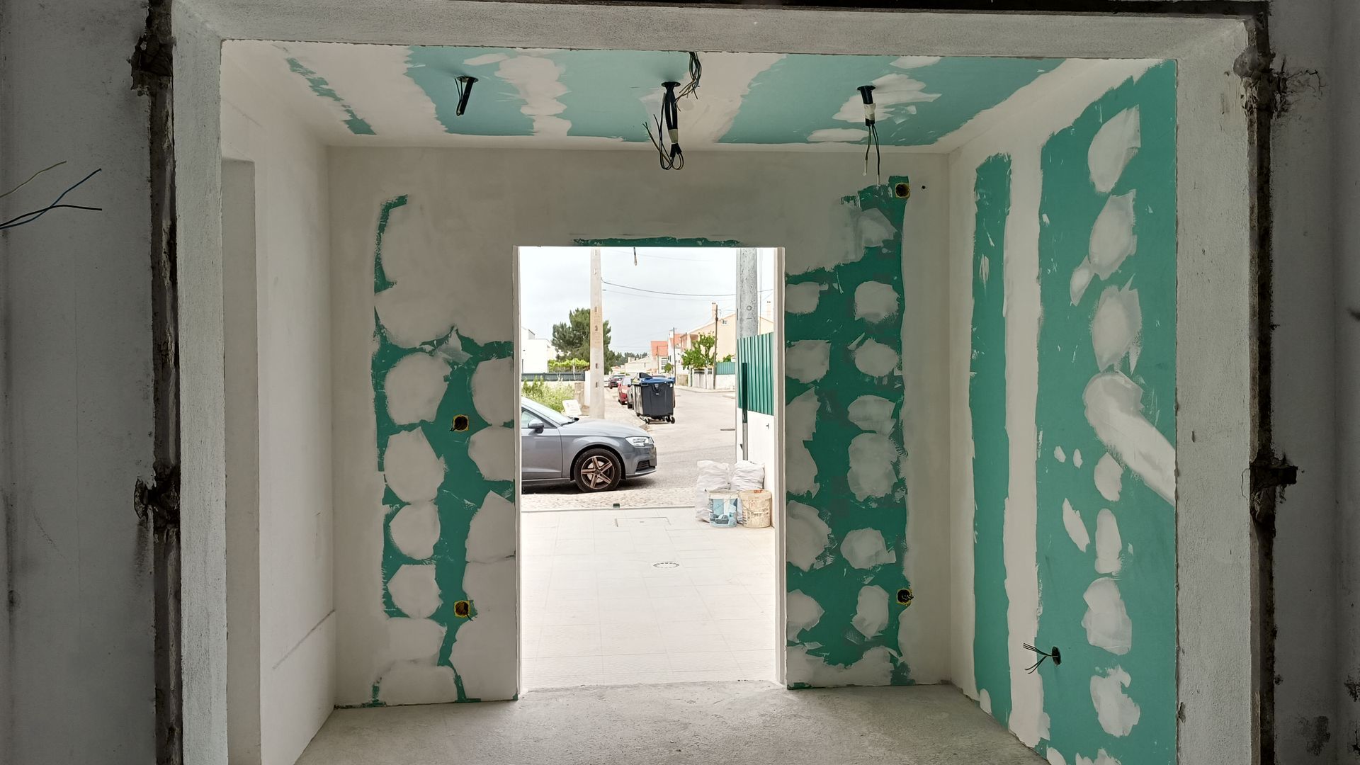 Porta interna em construção; parede de gesso acartonado, vista para a rua.