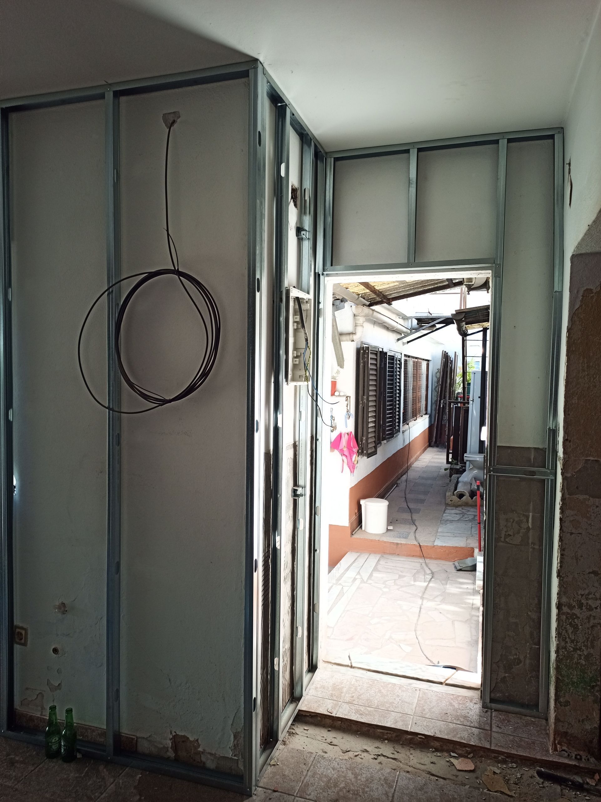 Estrutura metálica das paredes internas com porta de acesso ao pátio externo.