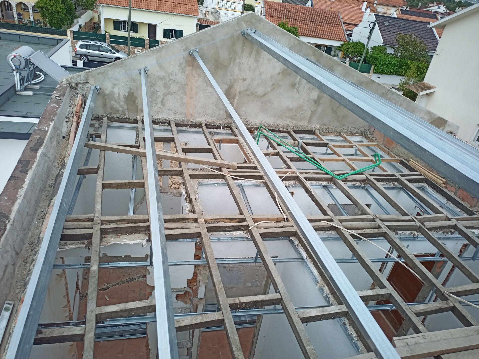 Construção do telhado em andamento com vigas de metal e madeira.