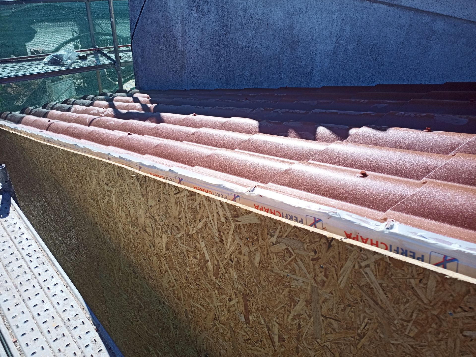 Nova construção de telhado: Telhas marrons, painéis de madeira, isolamento branco.