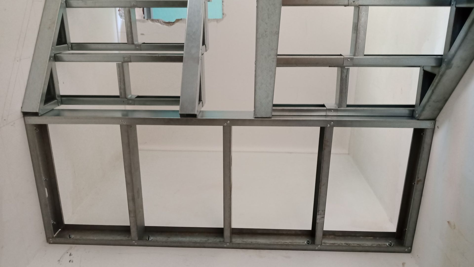 Estrutura metálica para teto ou parede com aberturas retangulares.