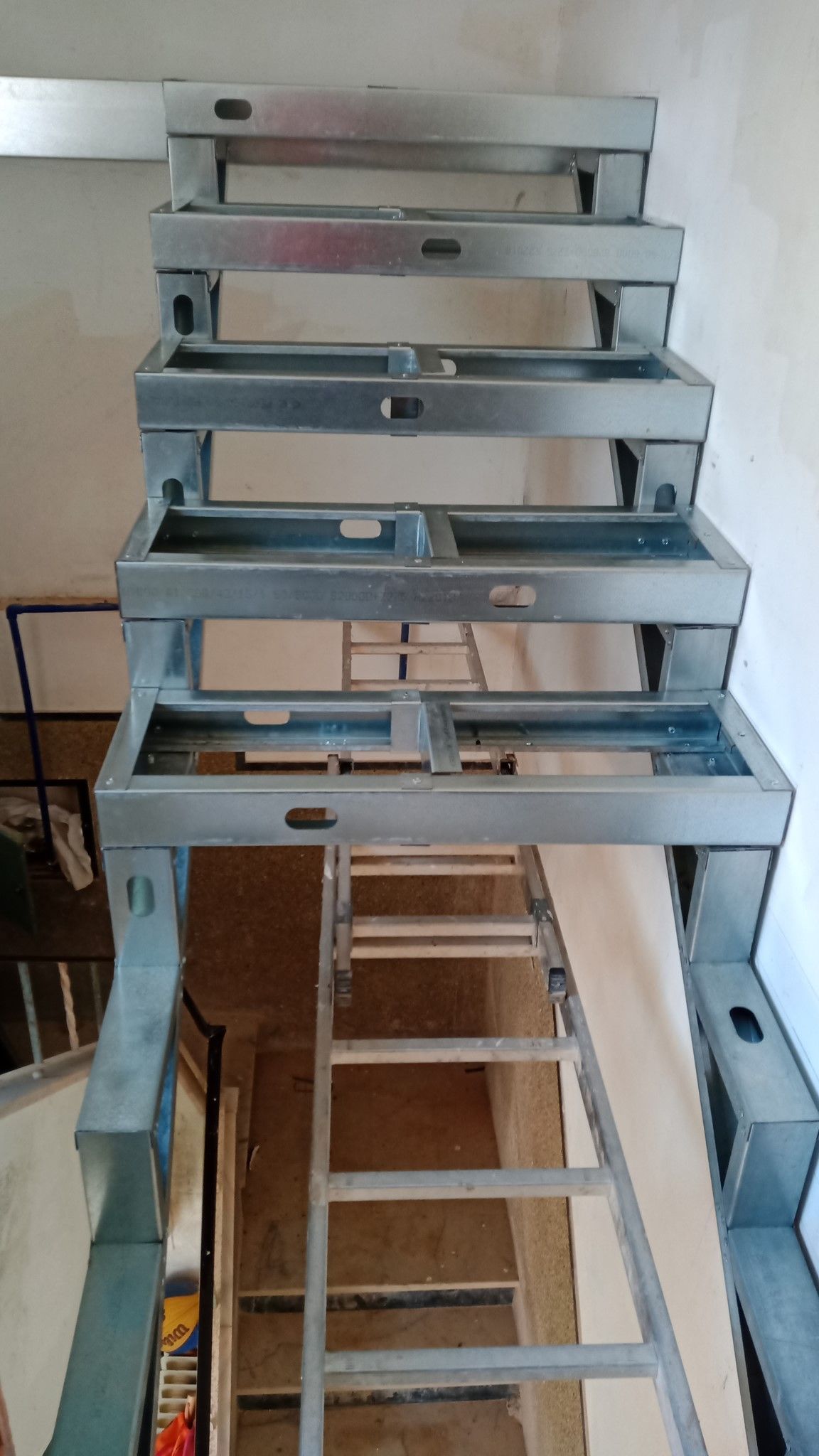 Estrutura metálica de escada em construção, que leva a um nível superior.