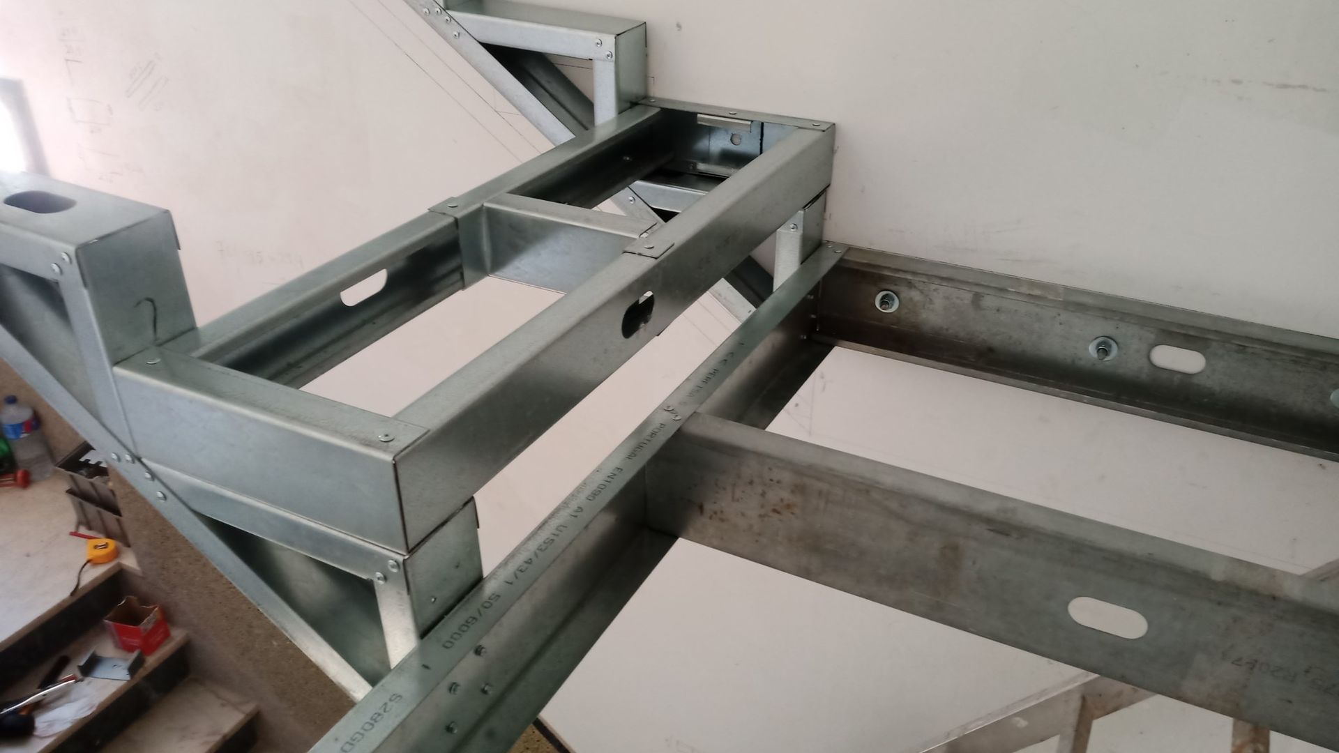 Estrutura metálica instalada em uma parede e teto, provavelmente para drywall.