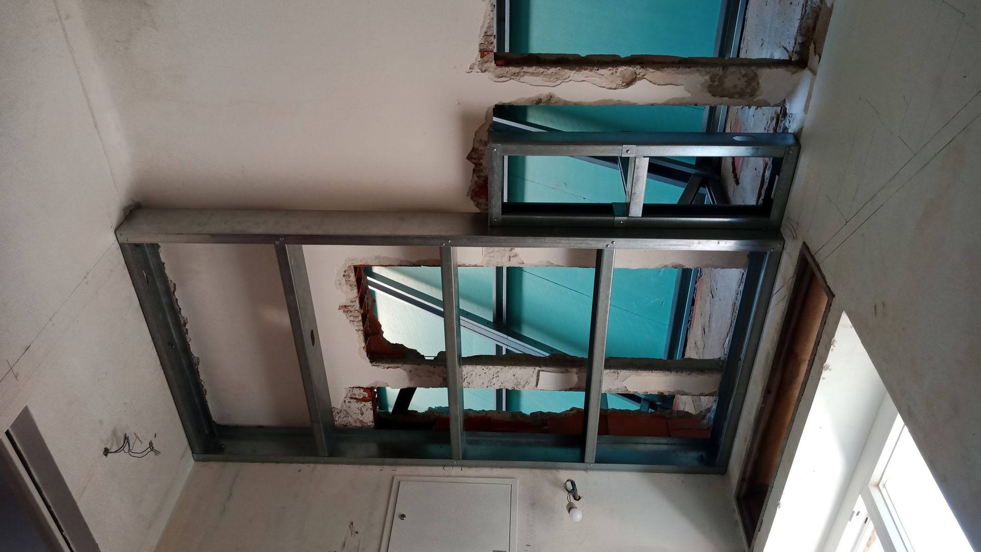 Teto com estrutura metálica e tijolos aparentes, provavelmente em construção.