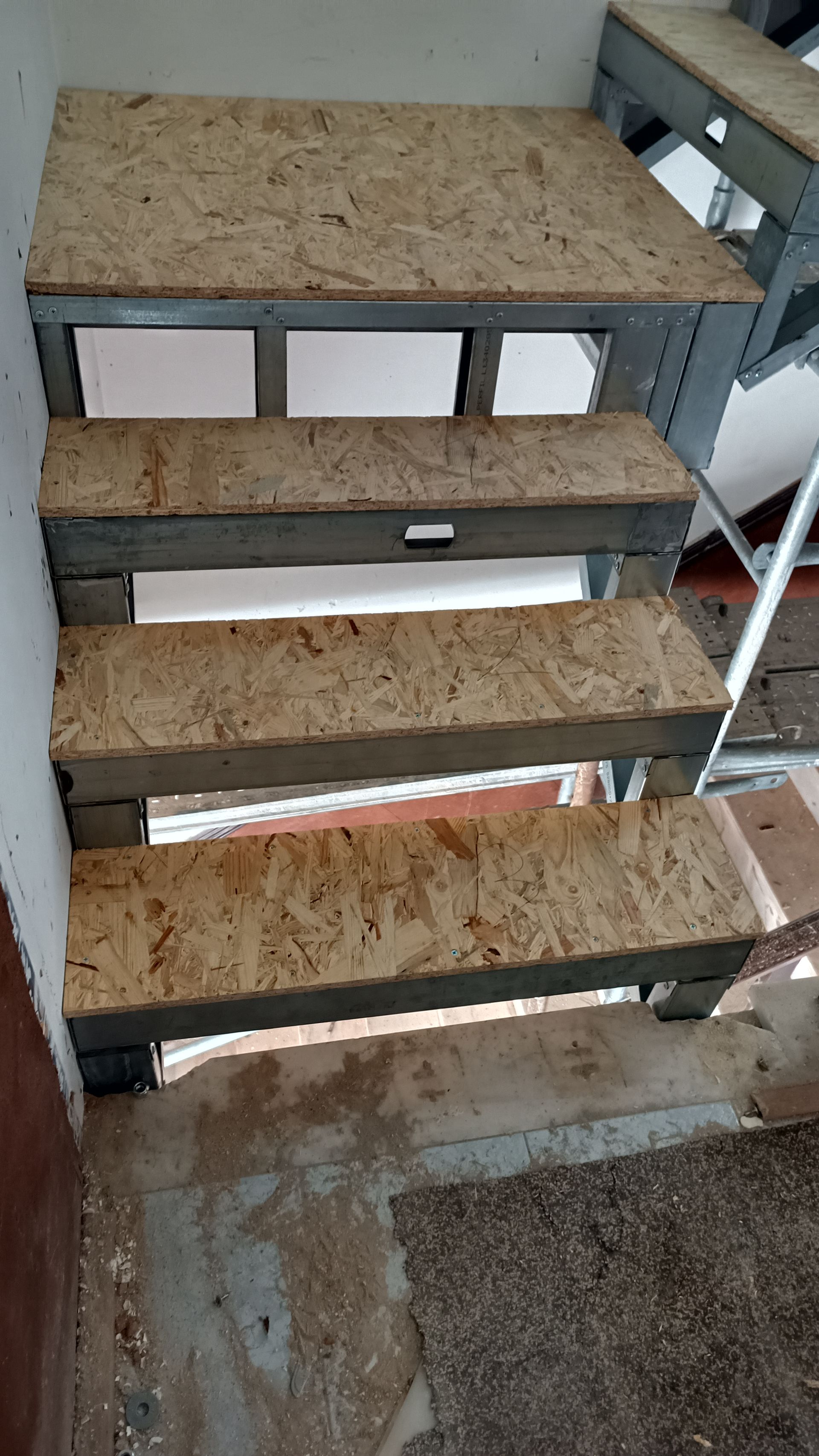 Escada com estrutura metálica e degraus em aglomerado de cor clara.