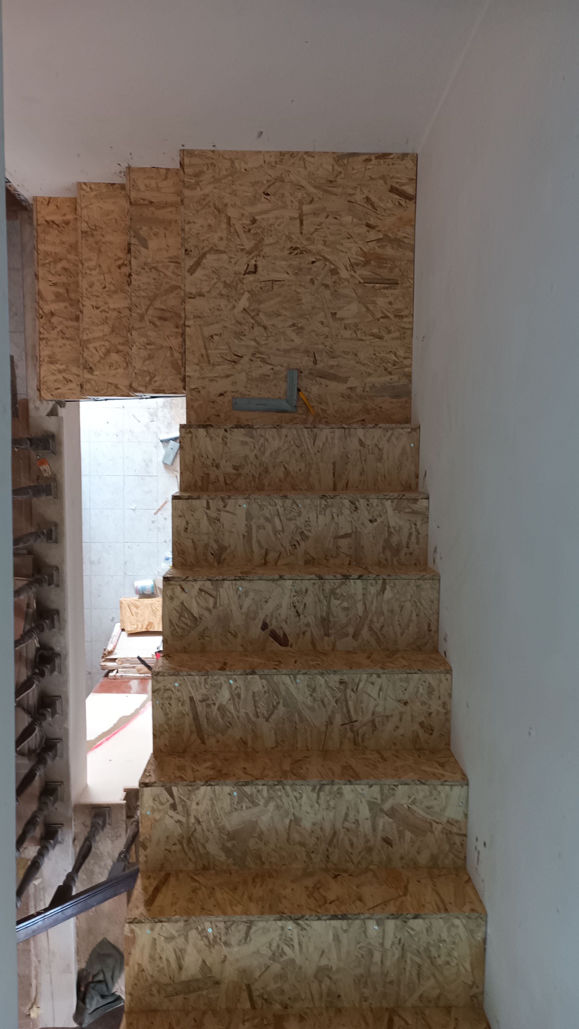 Escada em construção com degraus e paredes de OSB, vista de cima.