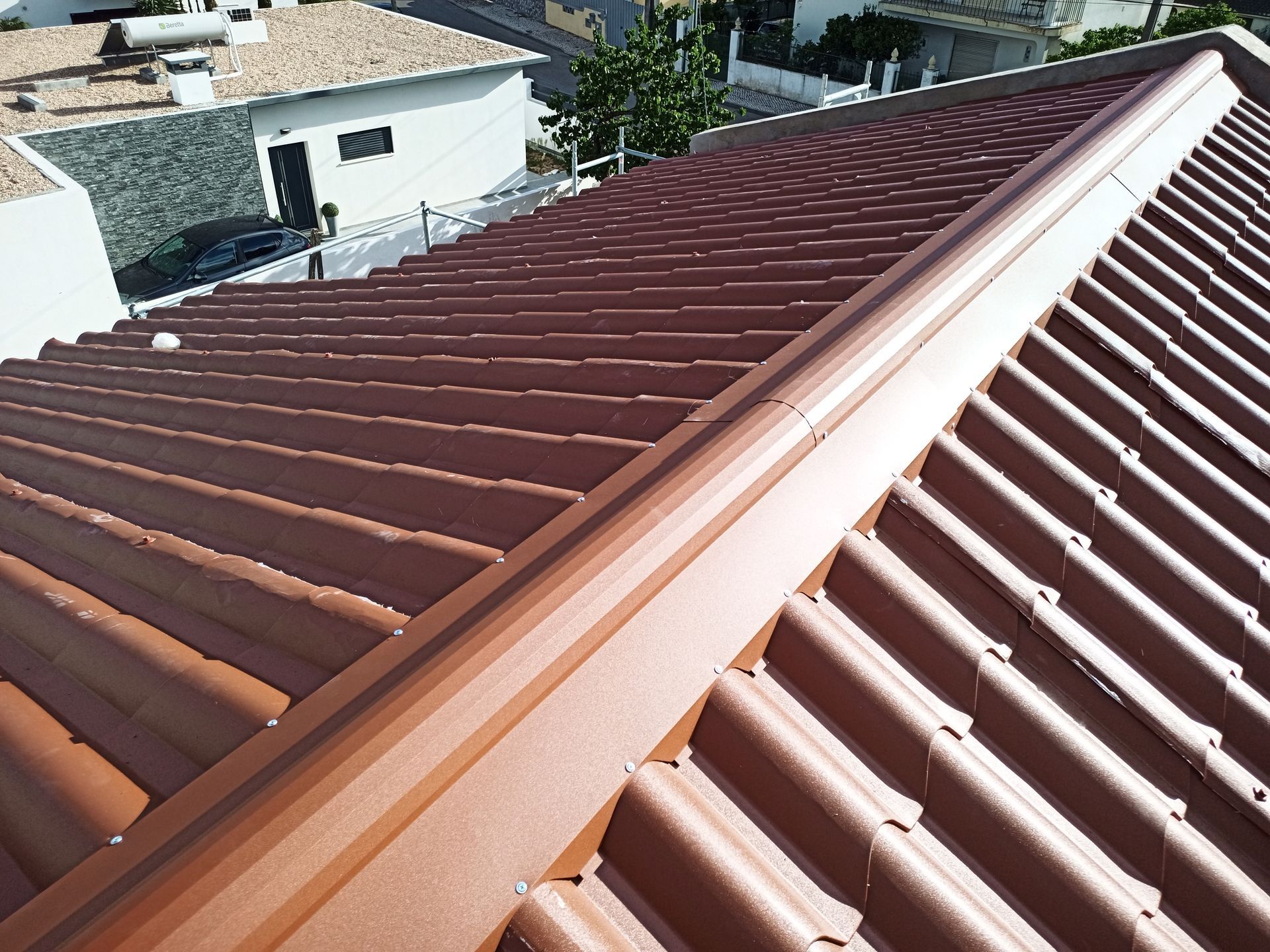 Telhado de metal ondulado marrom com calha combinando, vista em ângulo.