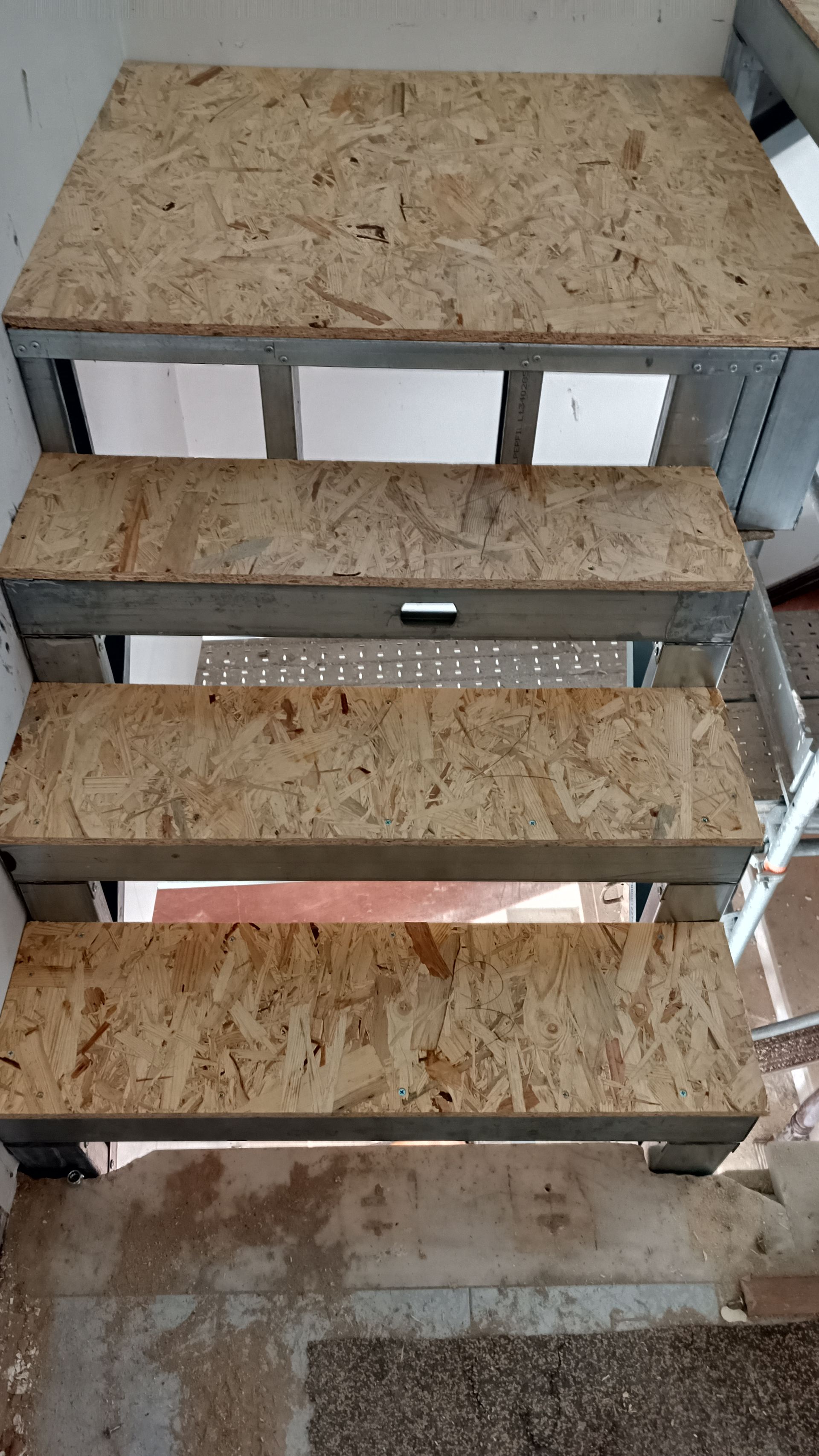 Escada metálica com degraus de madeira, em construção.