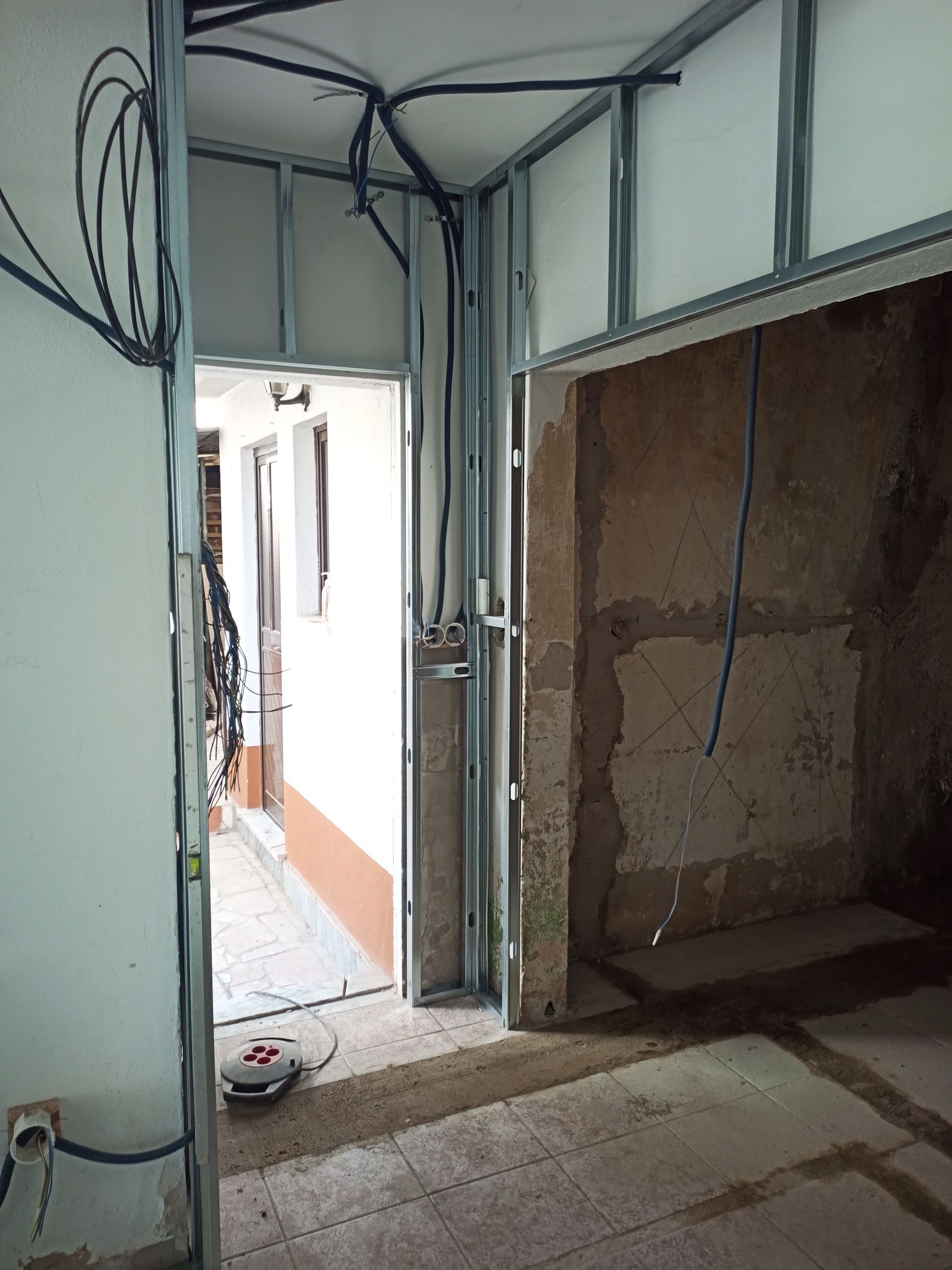 Construção interior: Estrutura metálica instalada para paredes e portas, com fiação elétrica exposta.