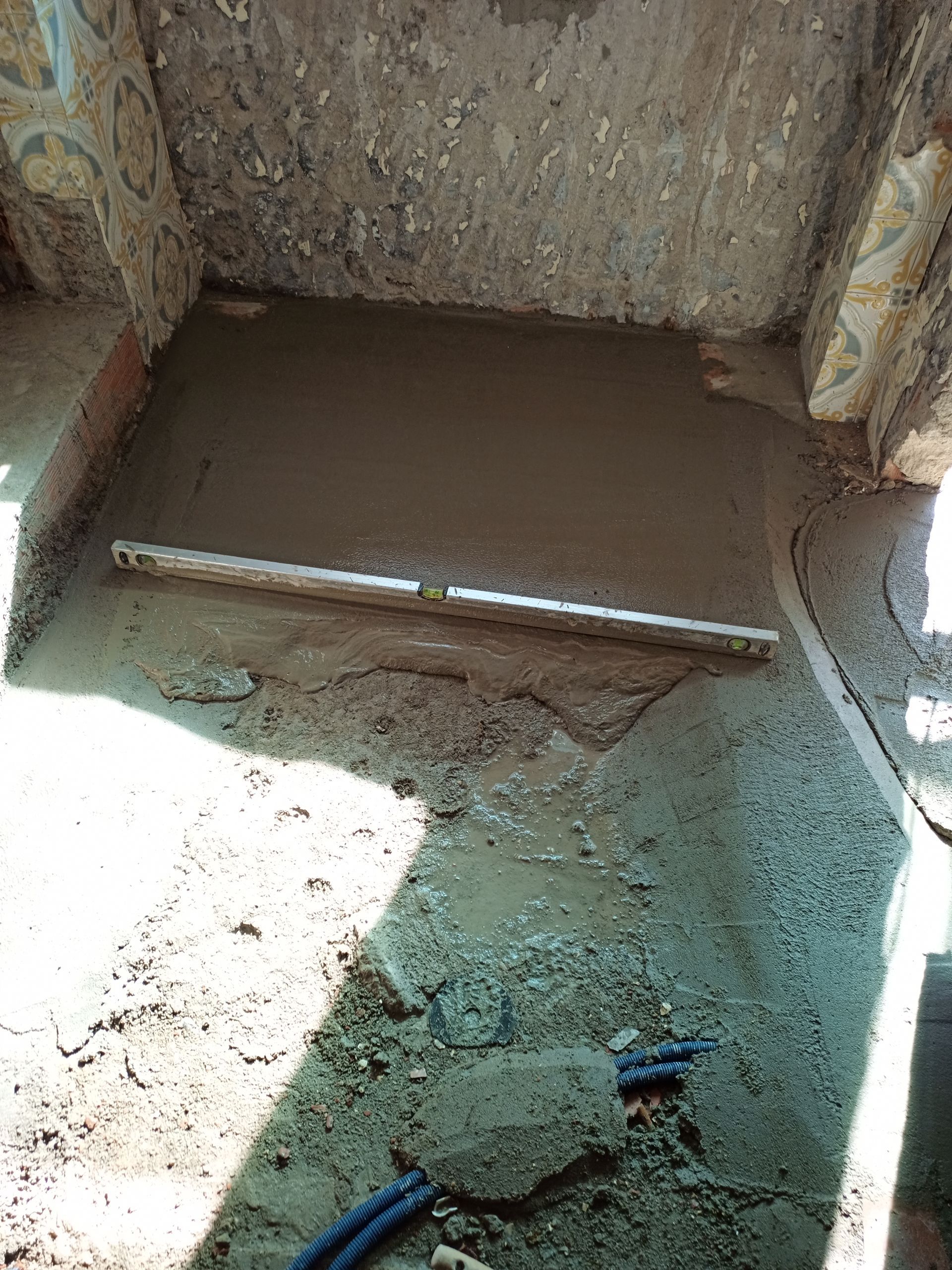 Cimento fresco despejado em uma área de construção, nivelado com uma ferramenta.