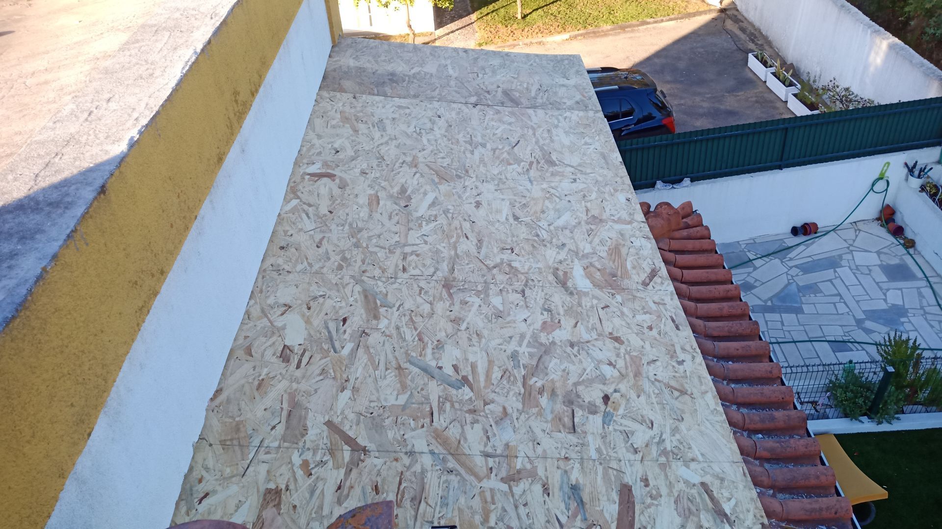 Painéis de OSB instalados ao lado de um telhado de telhas tradicional.