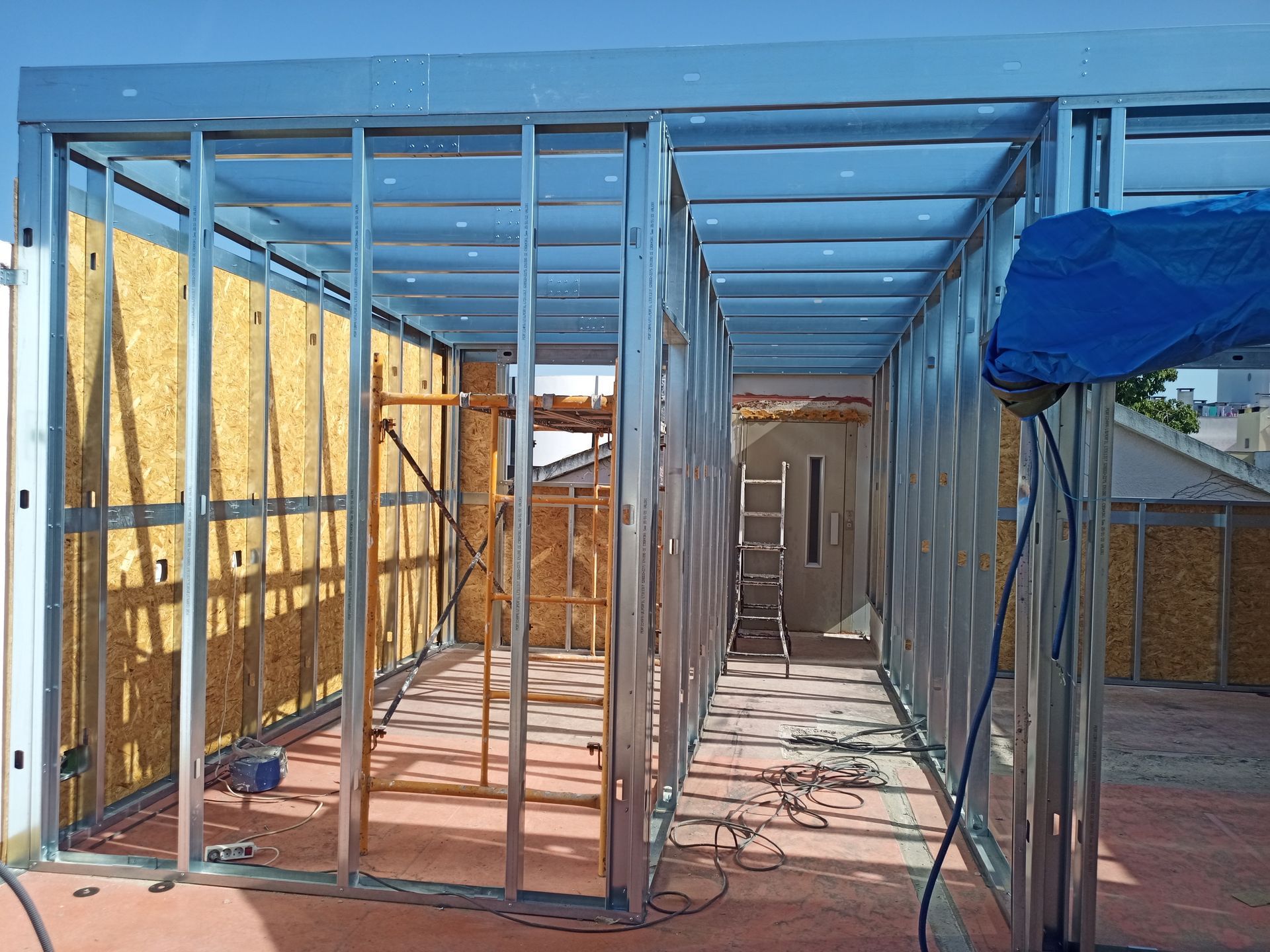 Estrutura metálica de um edifício em construção, com revestimento em OSB.