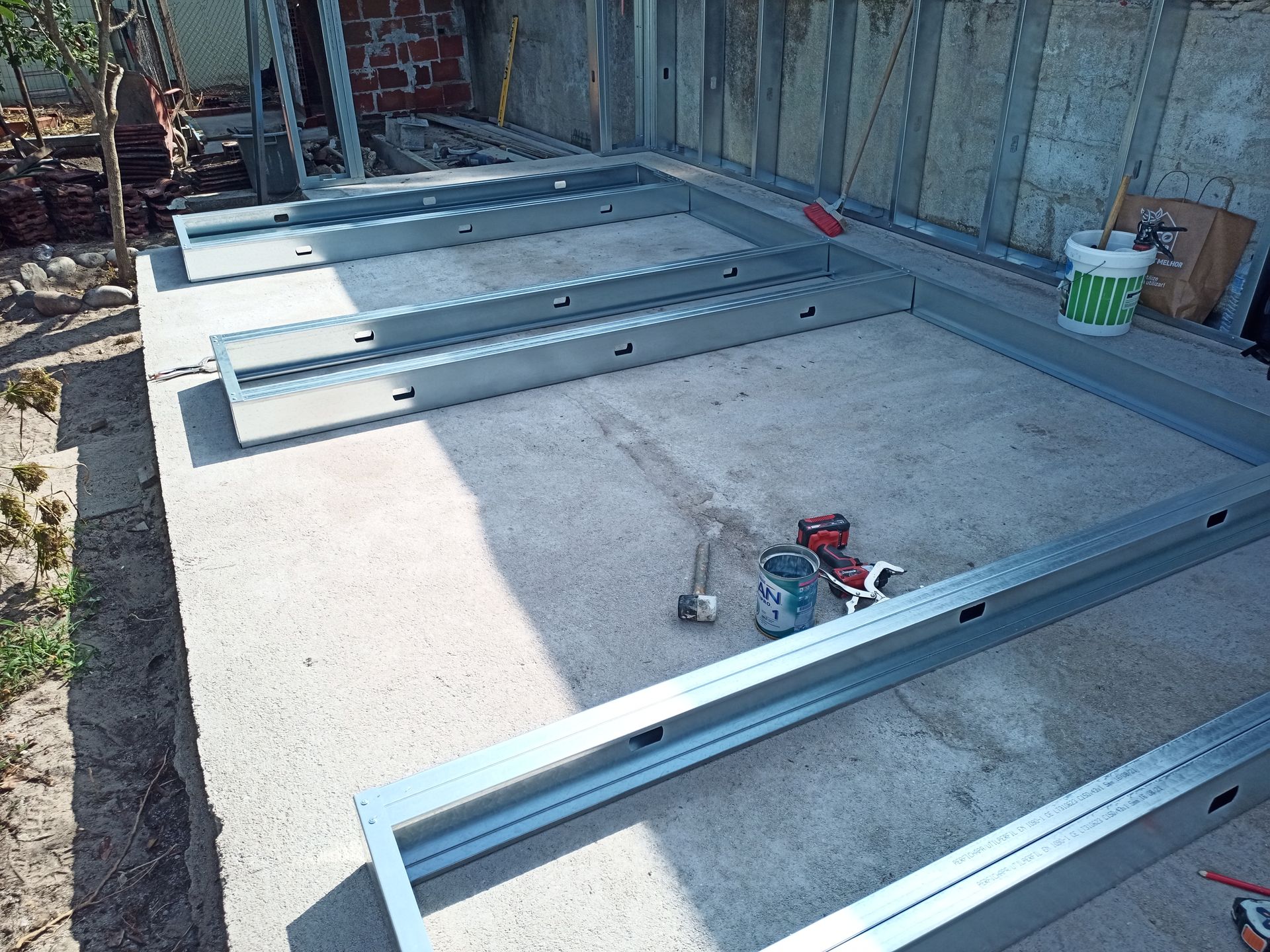 Estrutura metálica disposta sobre uma superfície de concreto para a construção de uma construção.