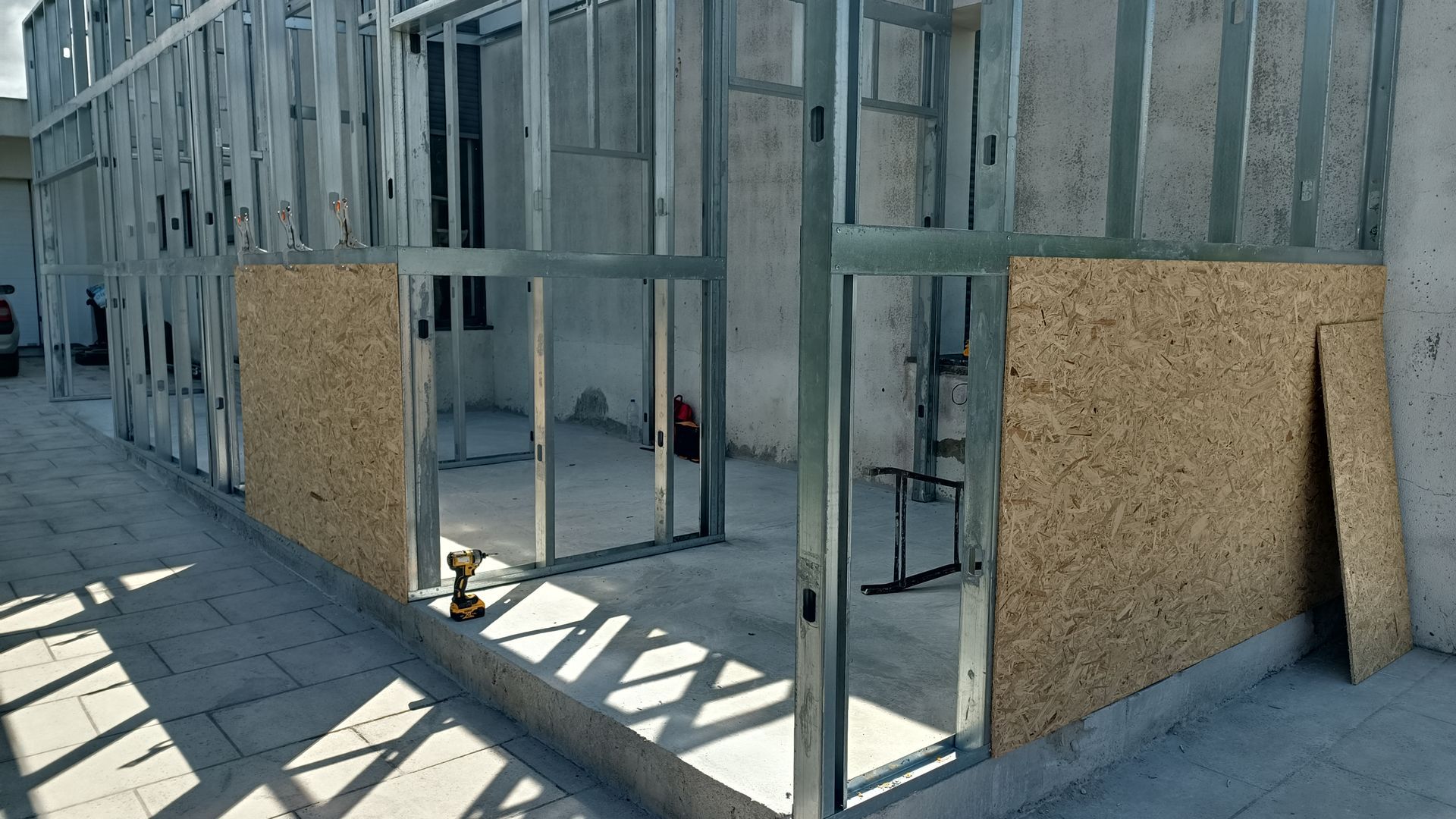 Construção com estrutura metálica e painéis de madeira parcialmente instalados, para uso externo.