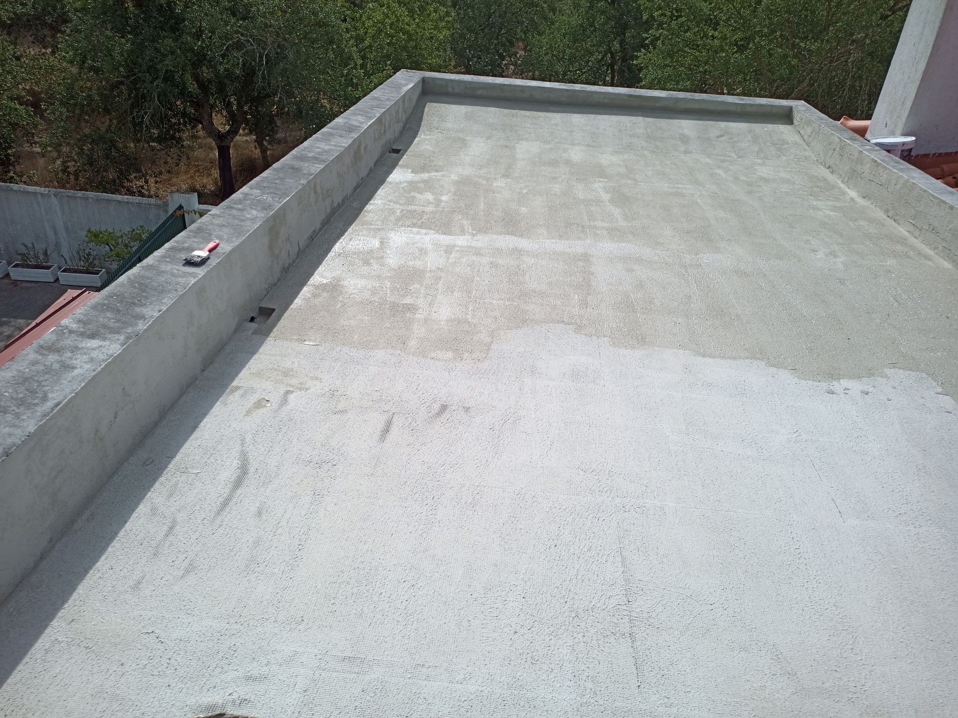 Telhado plano de concreto com borda elevada.