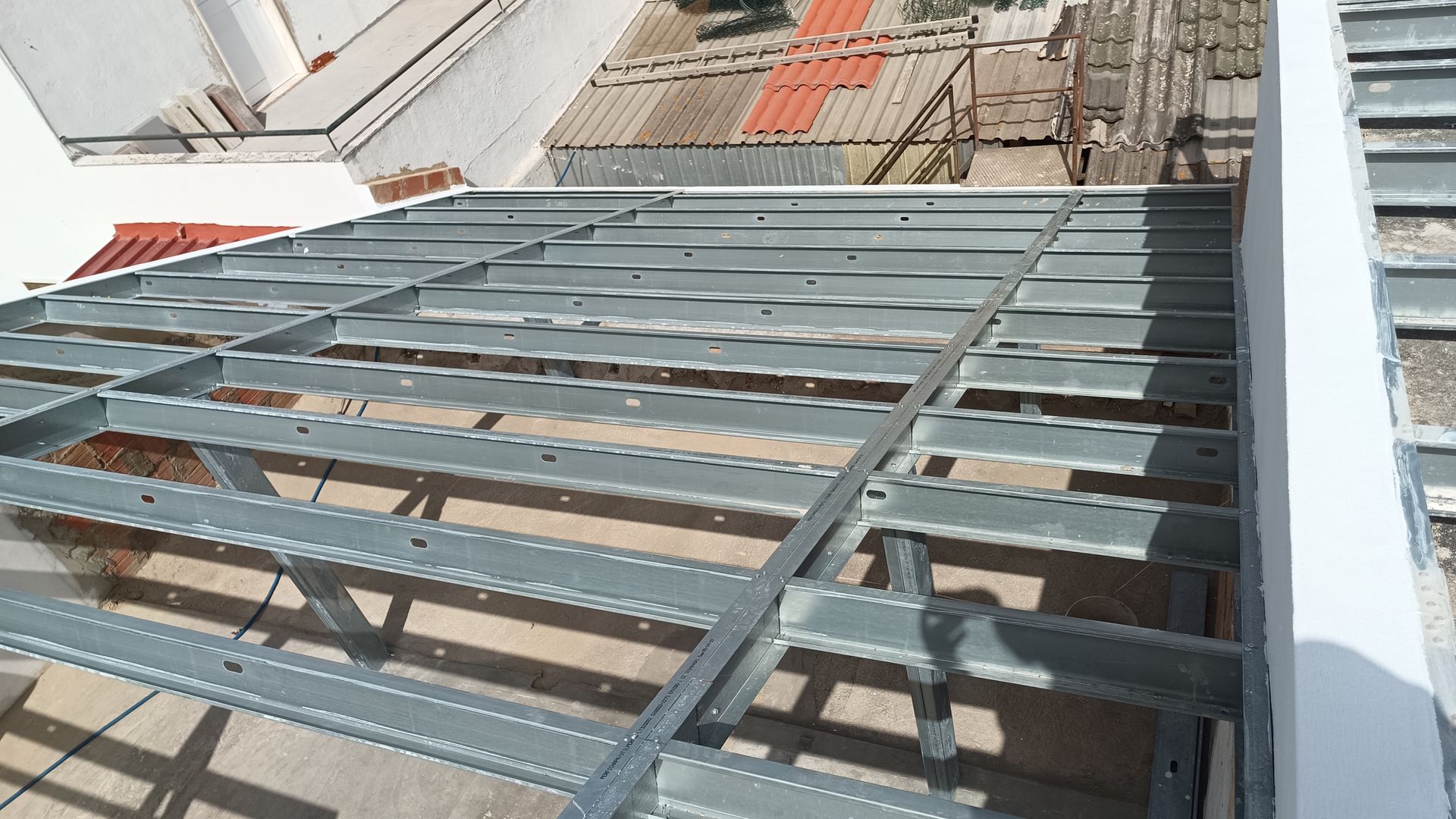 Estrutura do telhado em metal, com fileiras de vigas de aço.