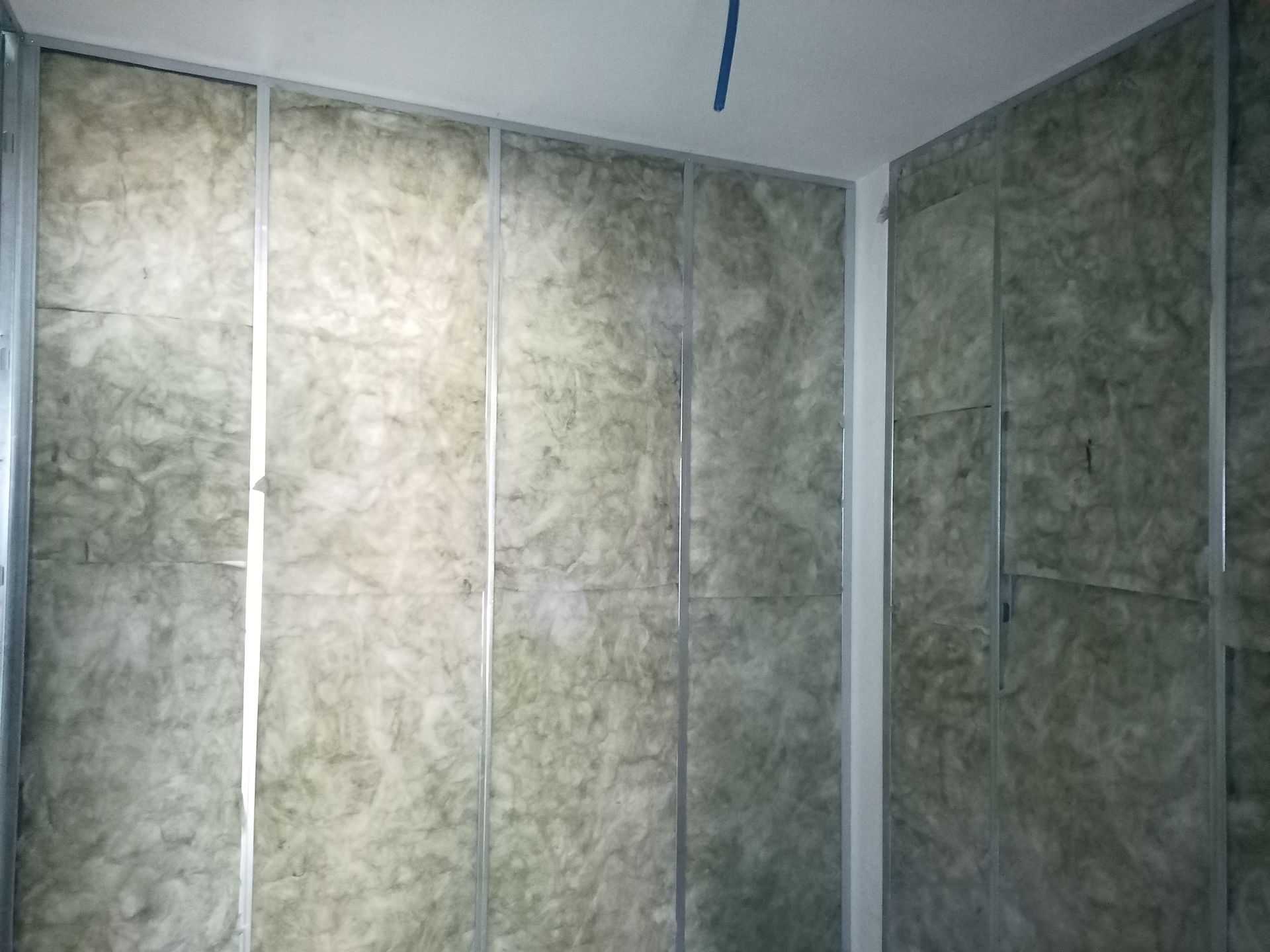 Paredes internas do cômodo com estrutura metálica e isolamento.