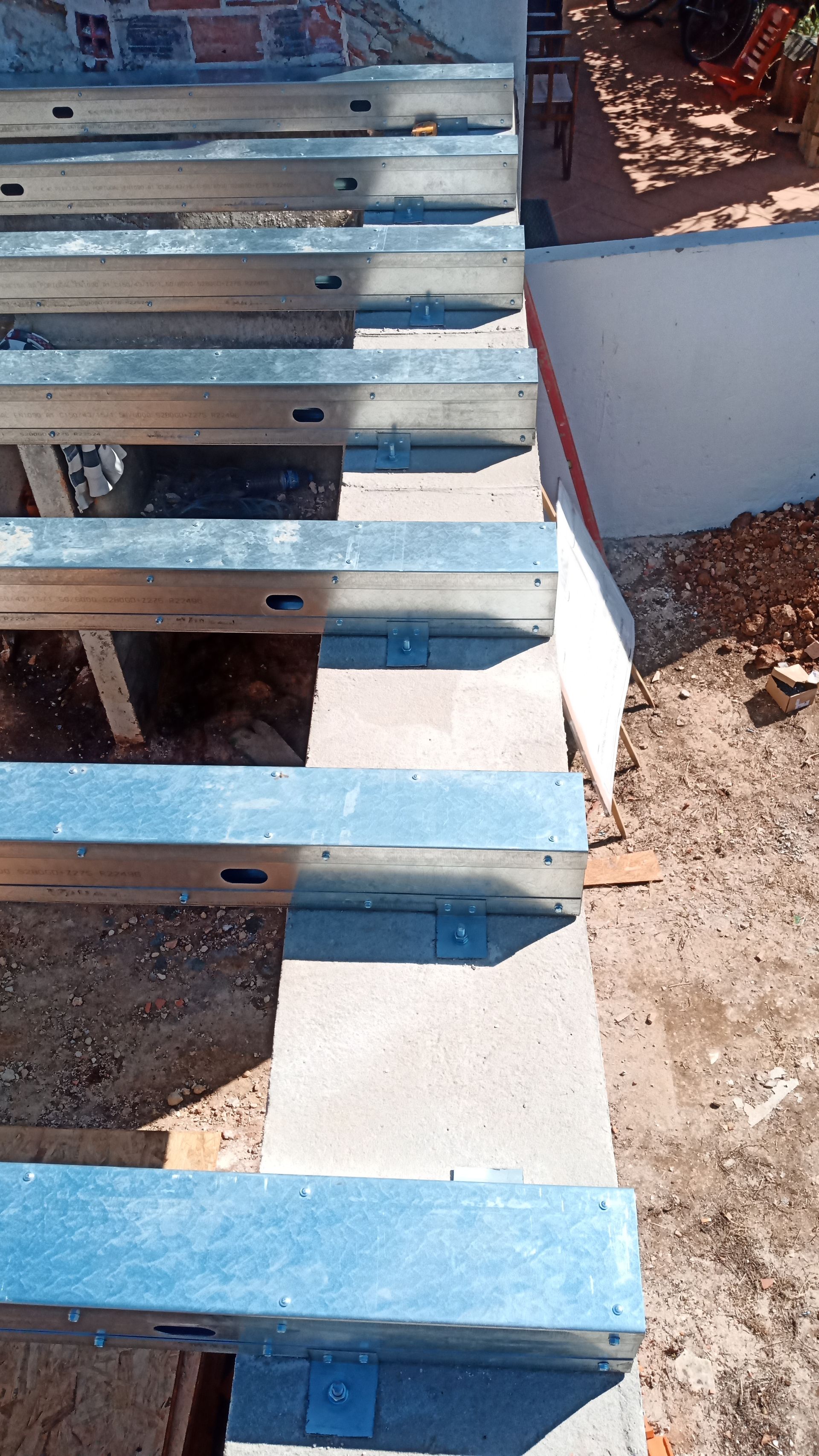 Estrutura metálica assentada sobre blocos de concreto; construção de um deck.
