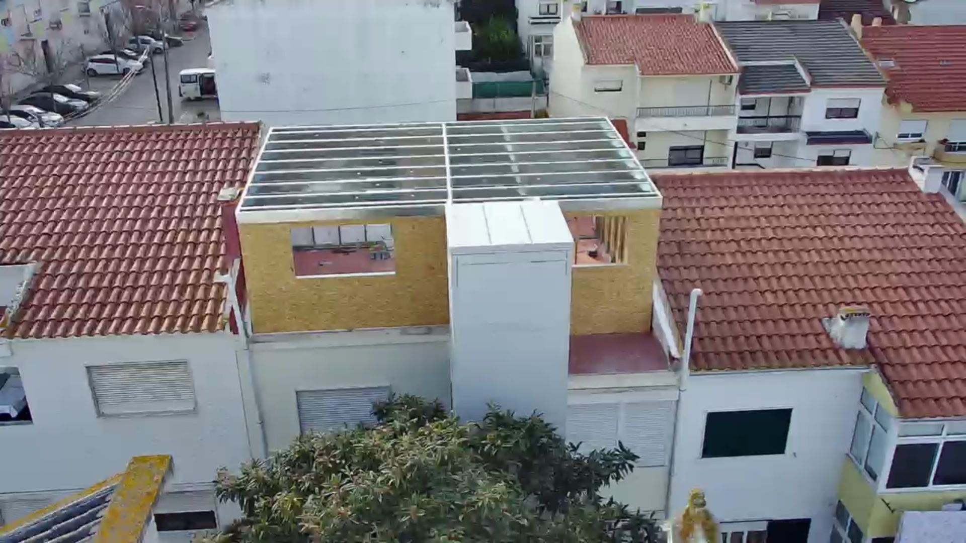 Vista aérea de um canteiro de obras em um prédio residencial com casas ao redor.
