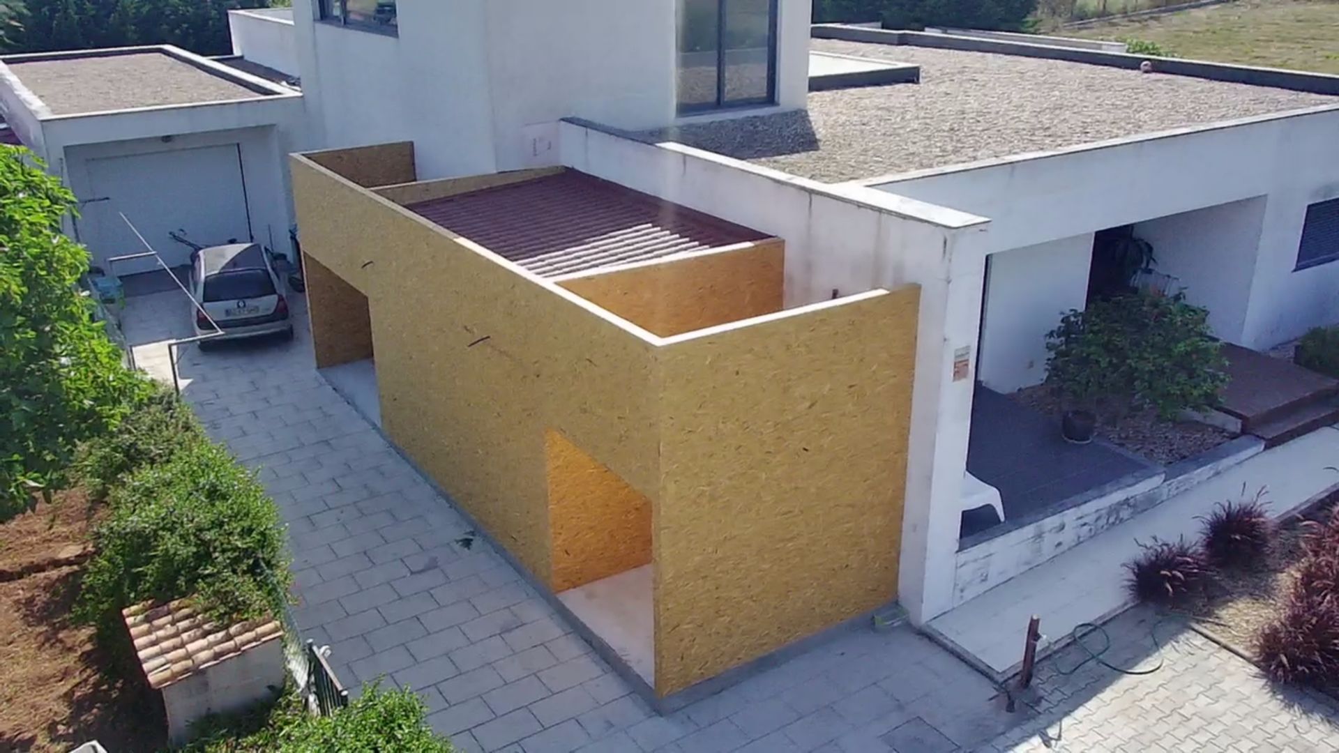 Casa residencial com garagem anexa, abrigo para carros, entrada para veículos e paisagismo.