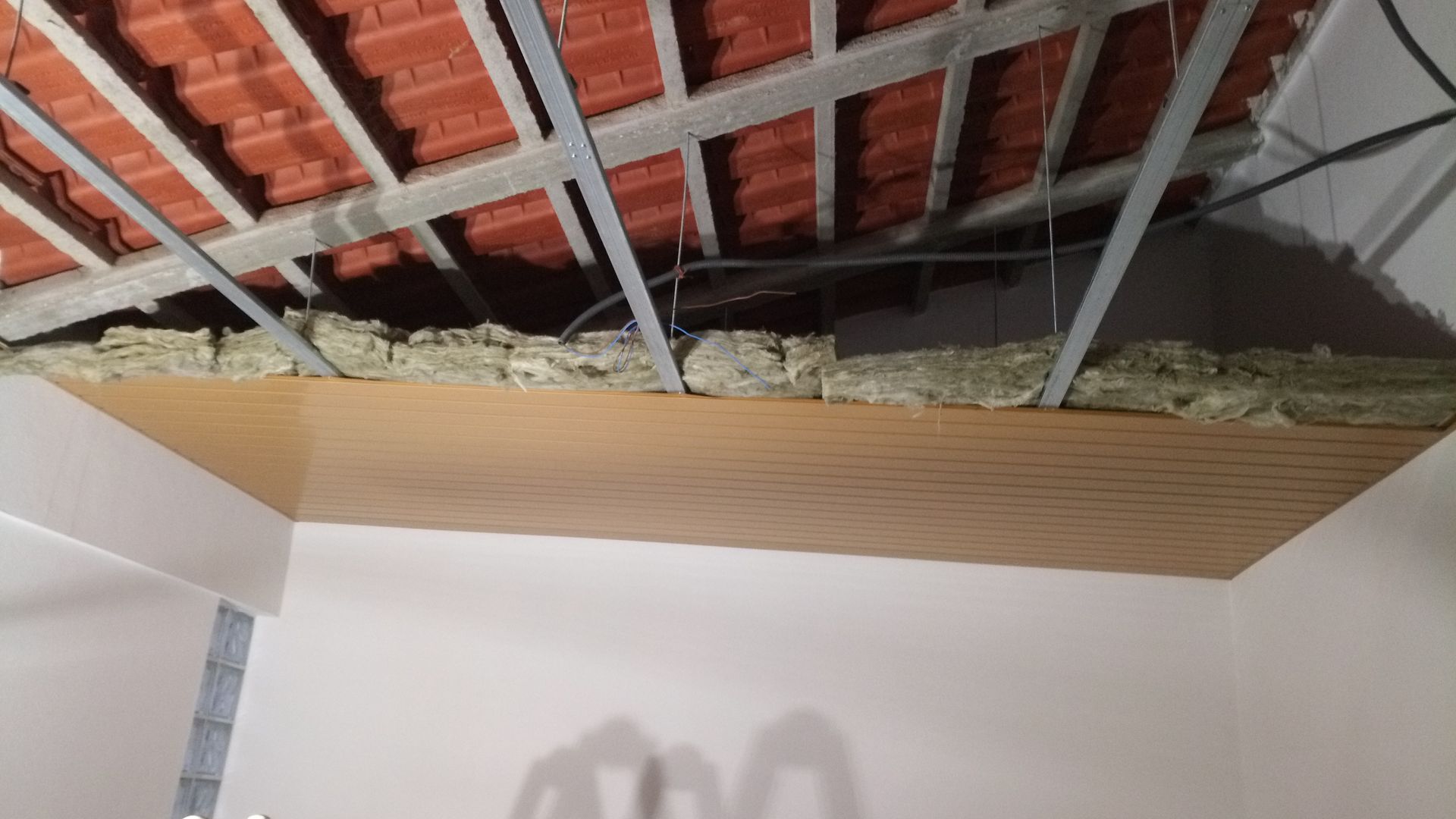 Construção de teto com cobertura aparente, isolamento e painéis novos.