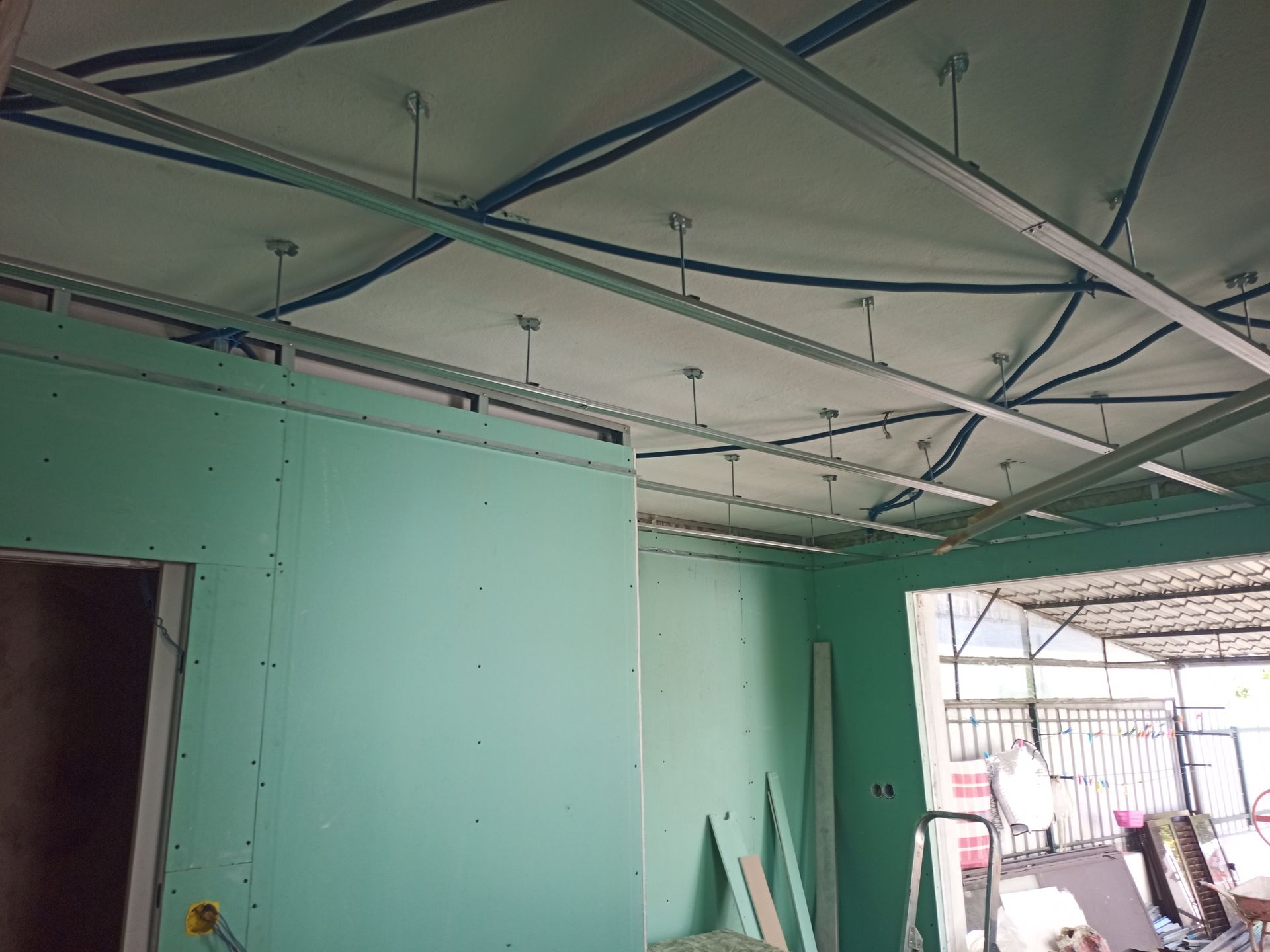 Construção interna: Paredes de gesso acartonado, estrutura do teto, fiação elétrica e encanamento visíveis.