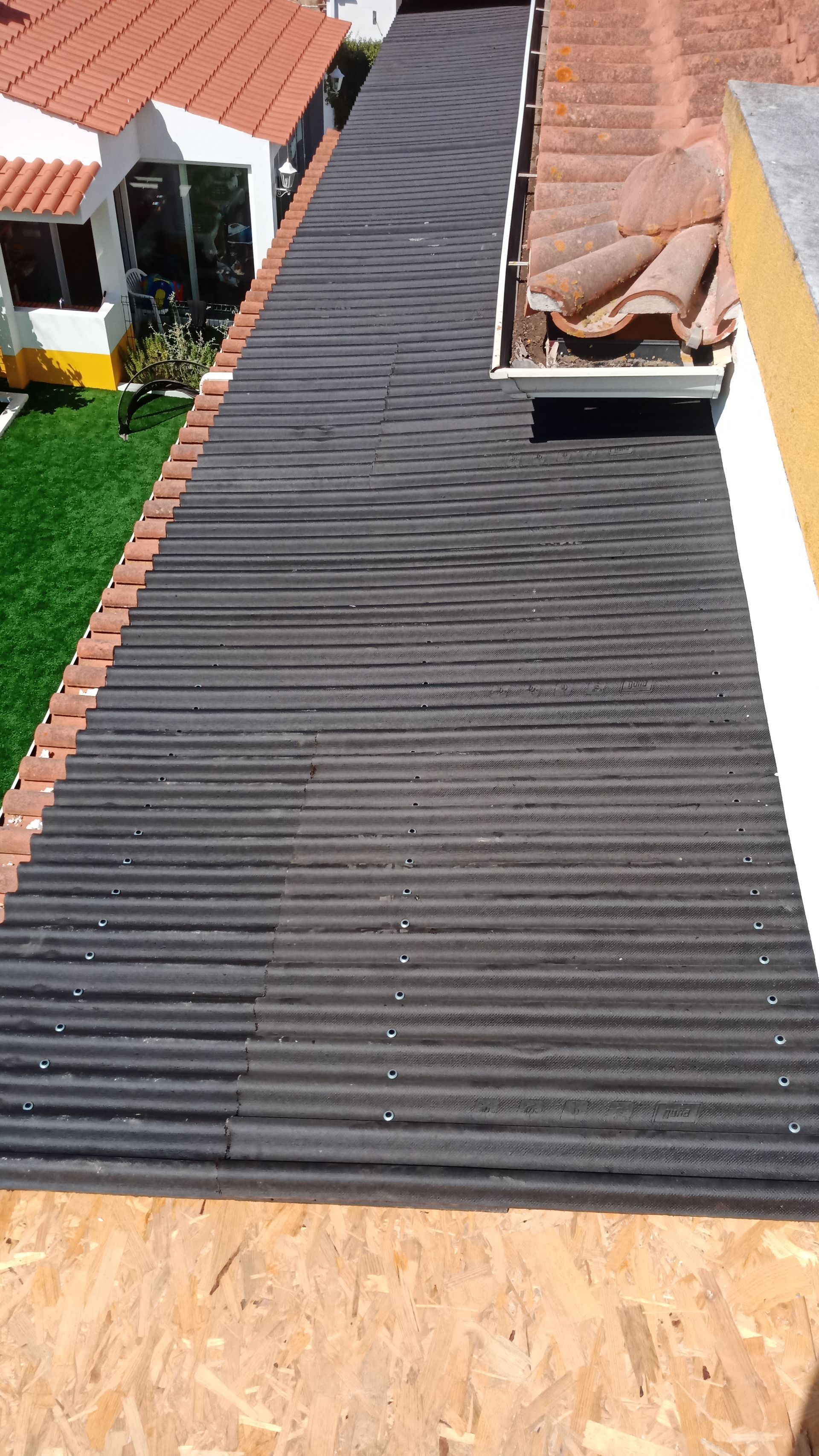 Telhado de zinco preto em um prédio, visto de um ângulo alto.