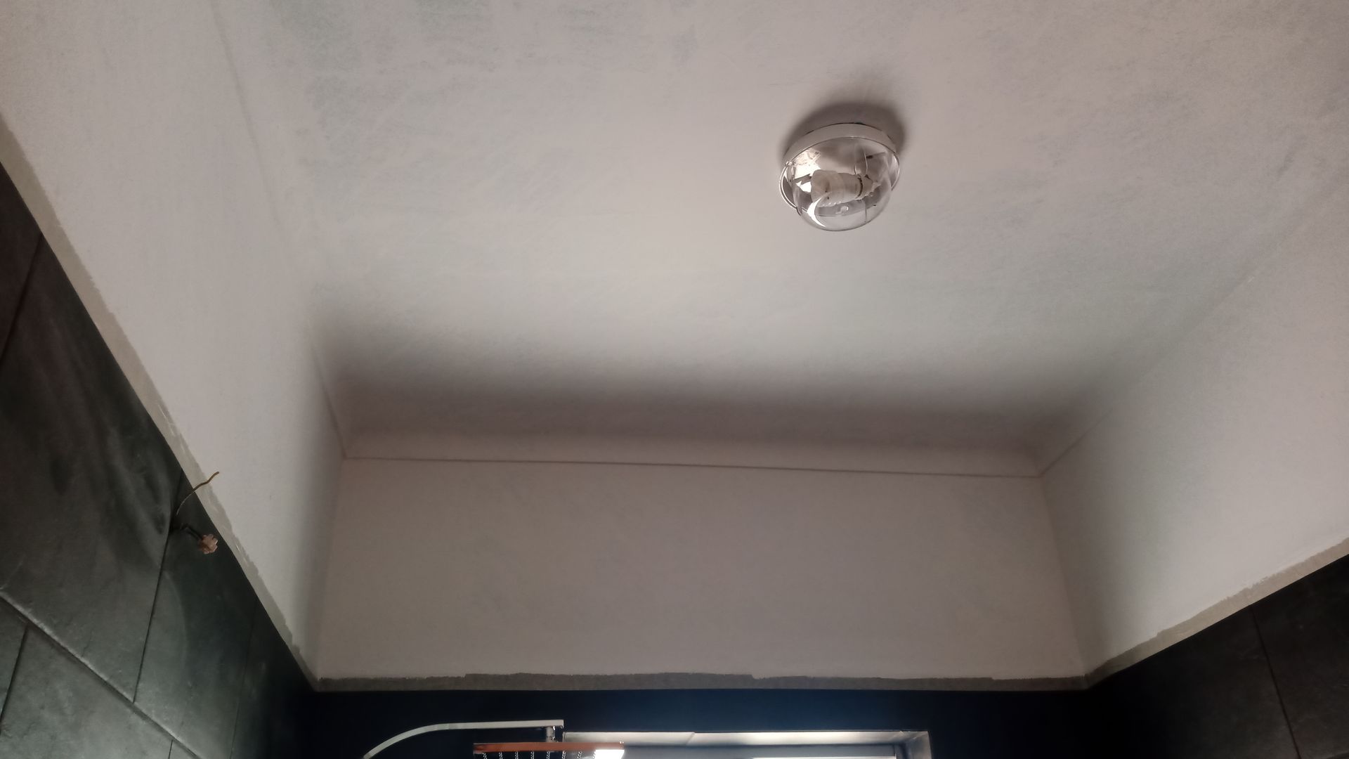 Teto branco com um detector de fumaça no centro.