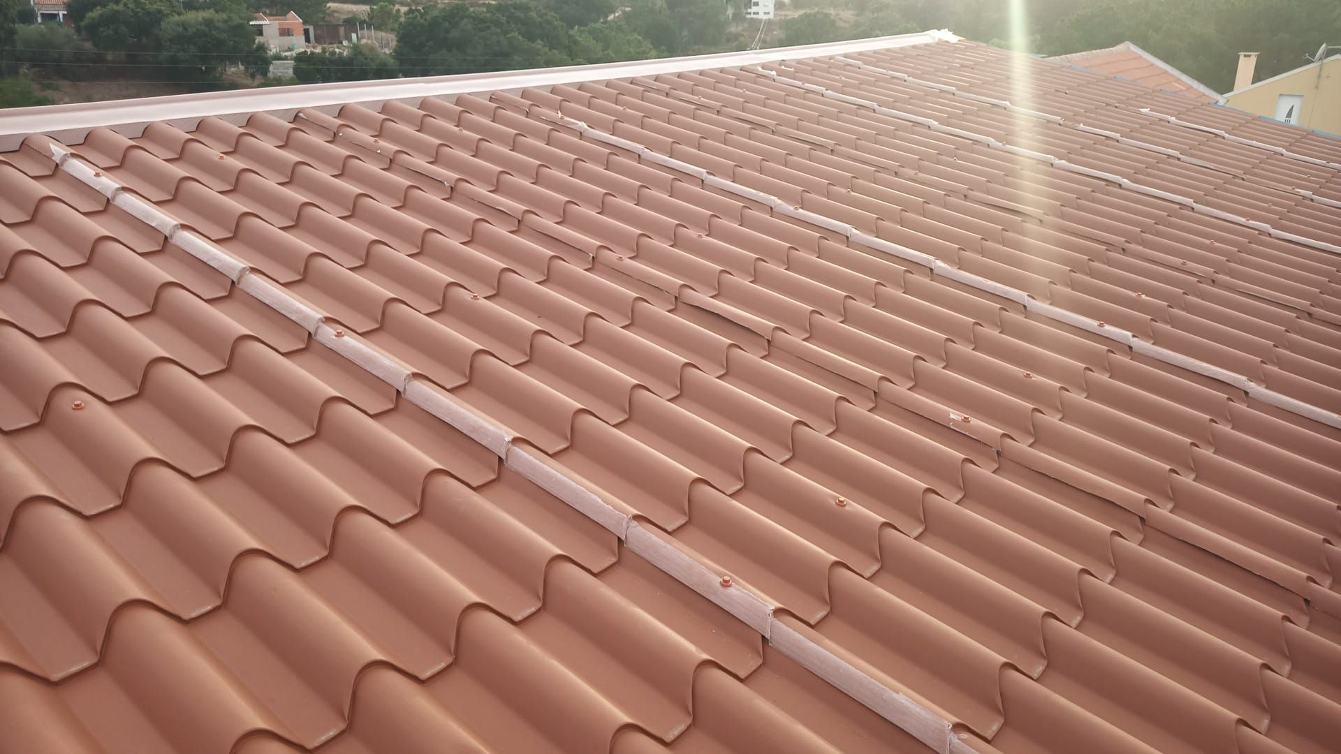 Telhado de telha de barro marrom com uma leve curvatura.