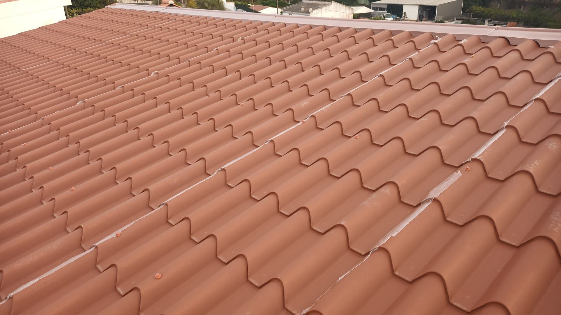 Detalhe de um telhado ondulado na cor terracota.