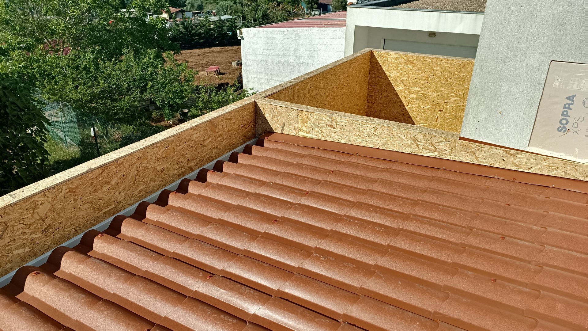 Telhado com telhas marrons e estrutura de madeira, ambiente externo ensolarado.