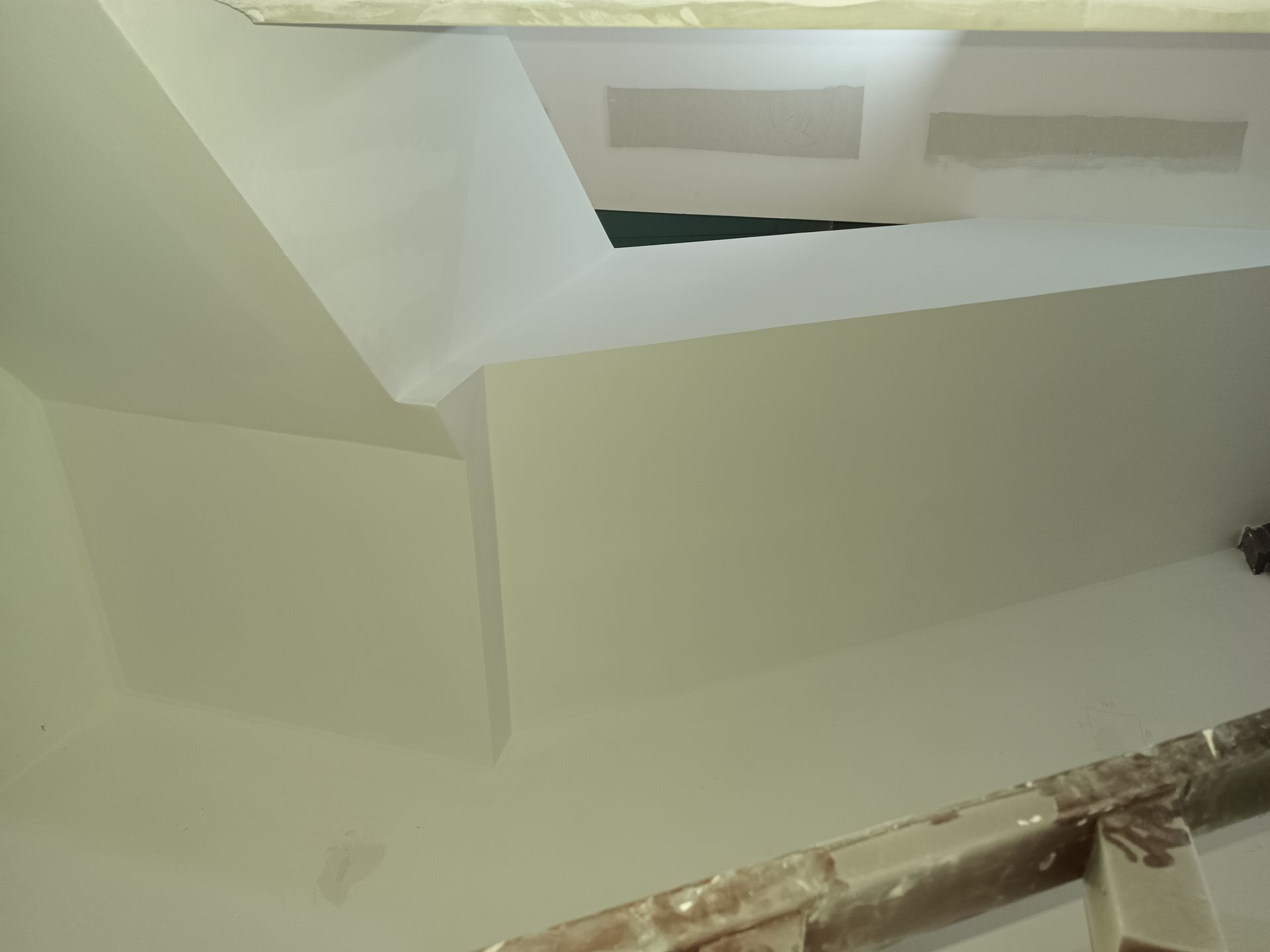 Teto pintado de branco com área rebaixada e escada.