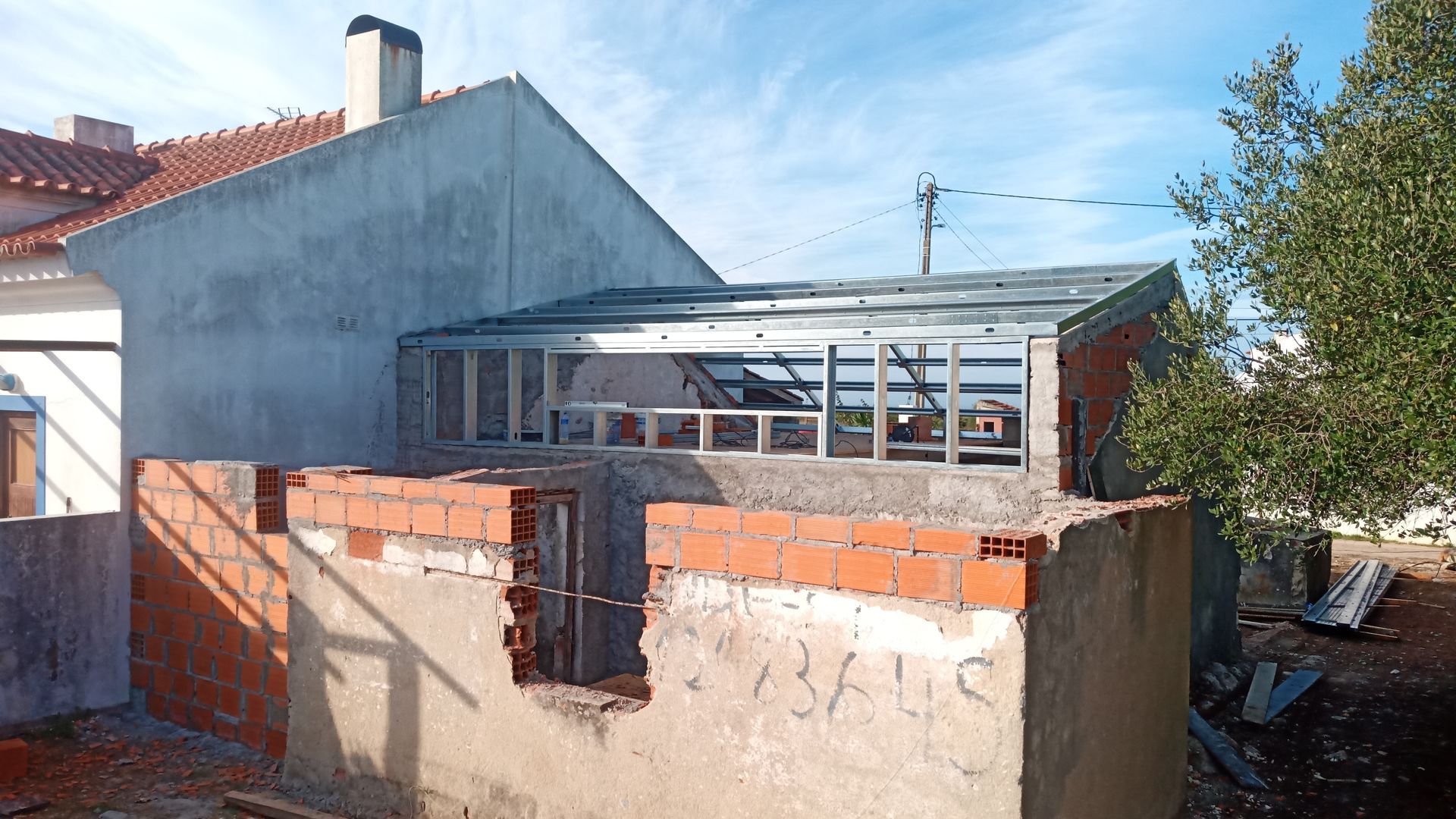 Construção de um edifício com tijolos aparentes e estrutura metálica contra um céu nublado.