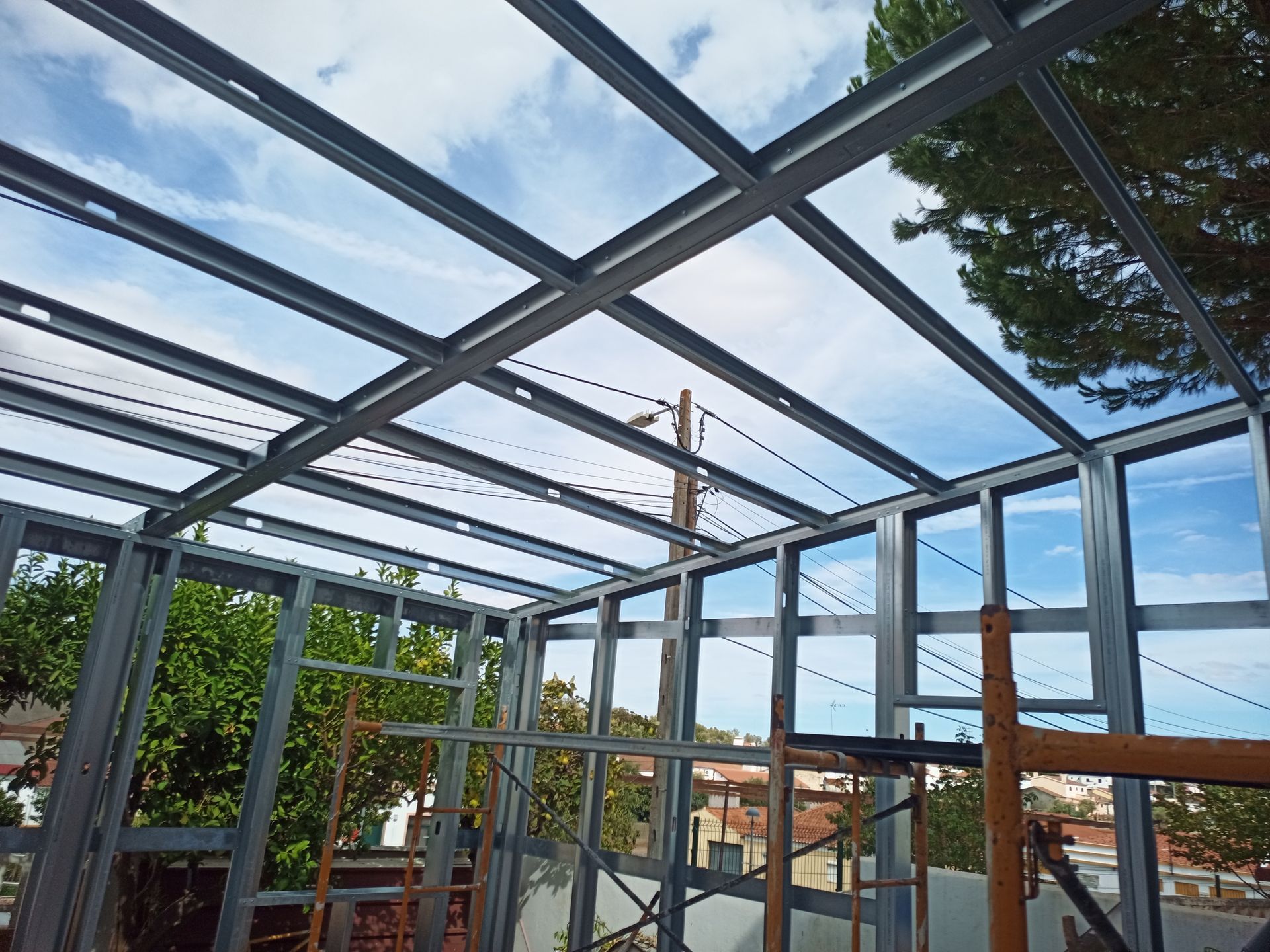 Estrutura metálica de um edifício com vigas e armação visíveis contra um céu nublado.