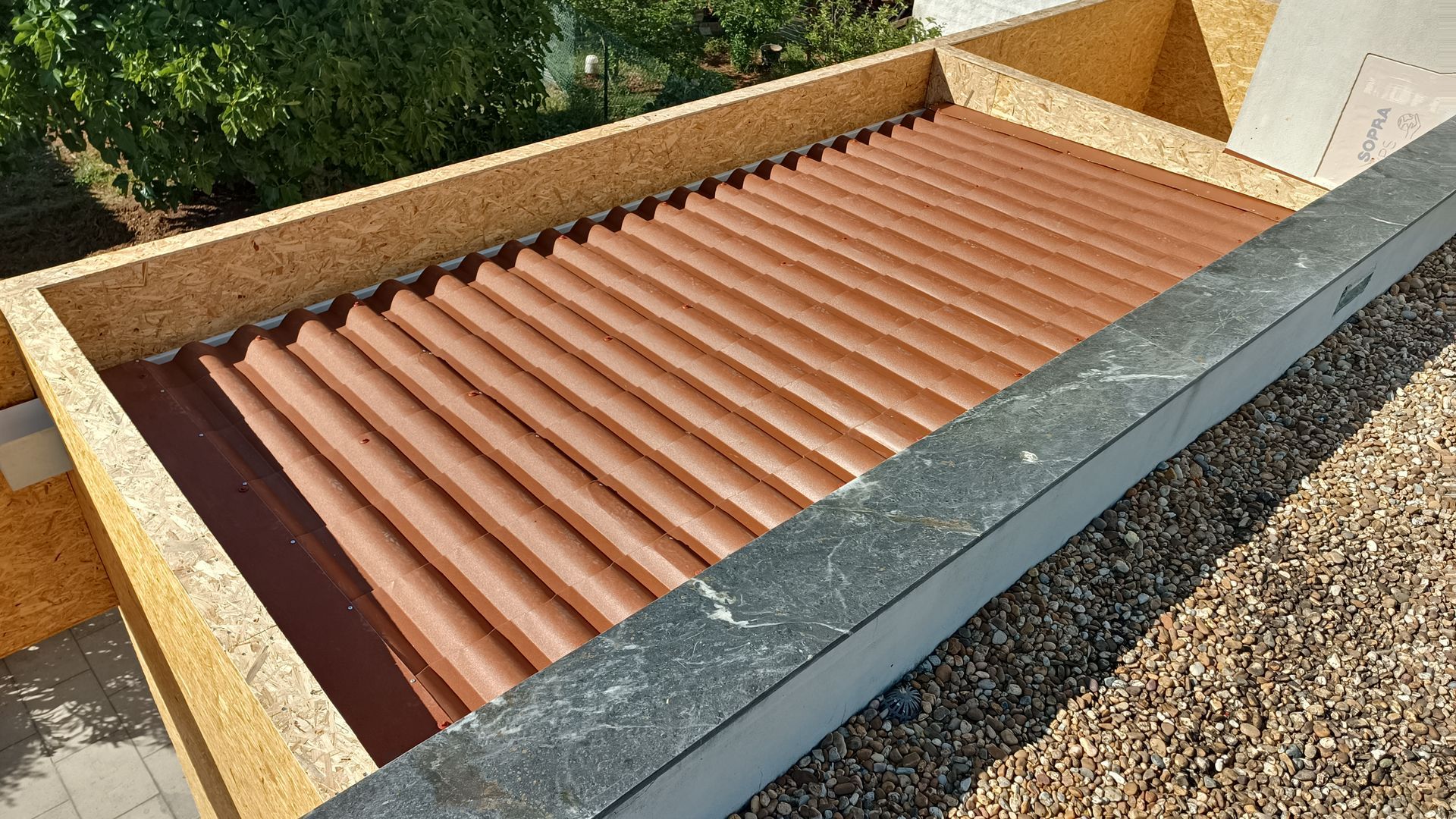 Telhado ondulado marrom dentro de uma estrutura de madeira, com borda cinza escura.