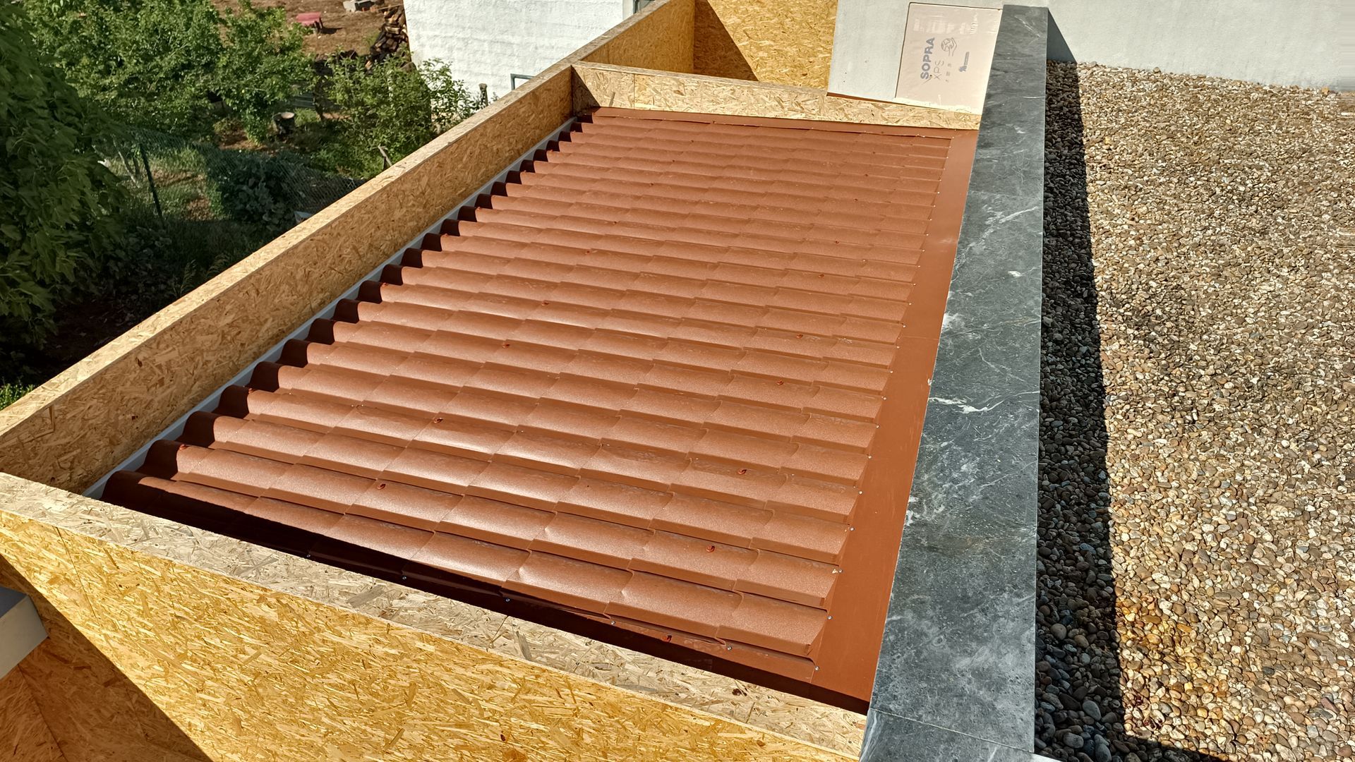 Telhado de metal ondulado marrom instalado em estrutura de madeira.