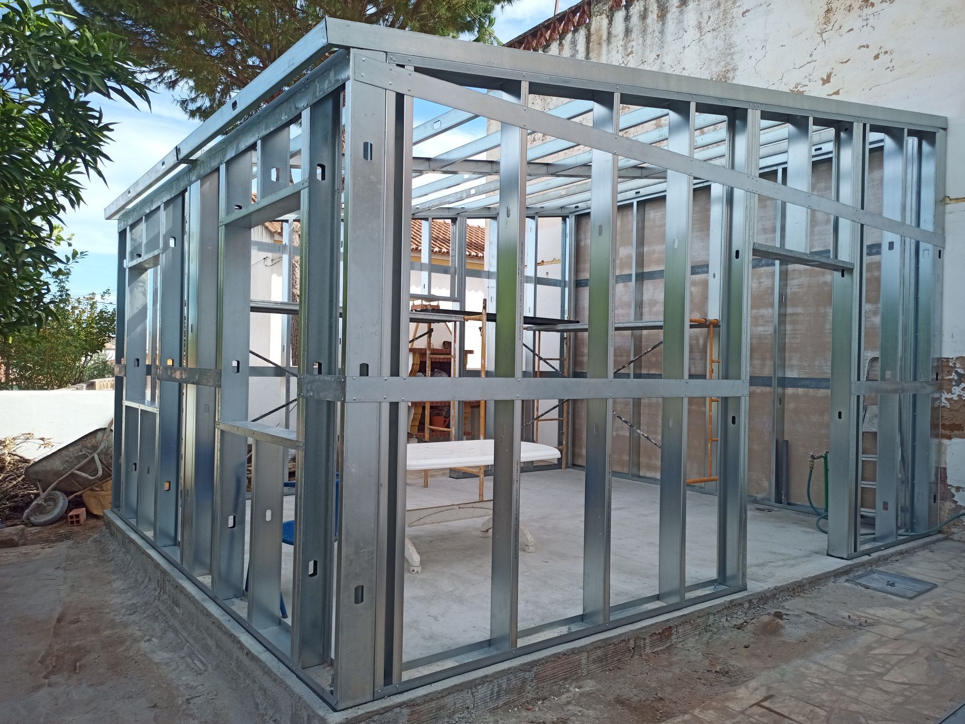 Estrutura metálica de um edifício em construção, vista exterior, com montantes e vigas de sustentação visíveis.