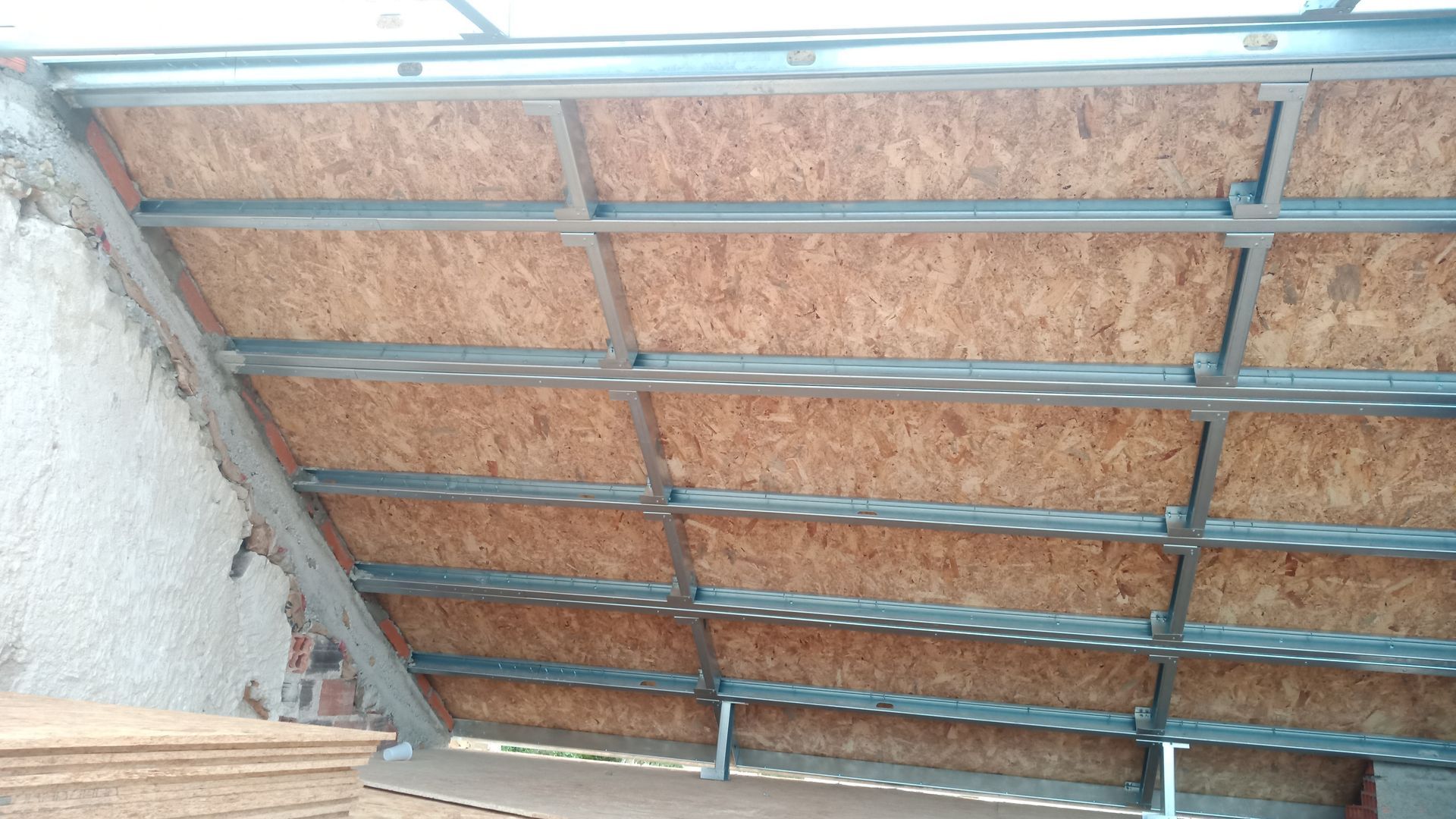 Construção de uma estrutura de teto inclinado com painéis de madeira instalados em um edifício.