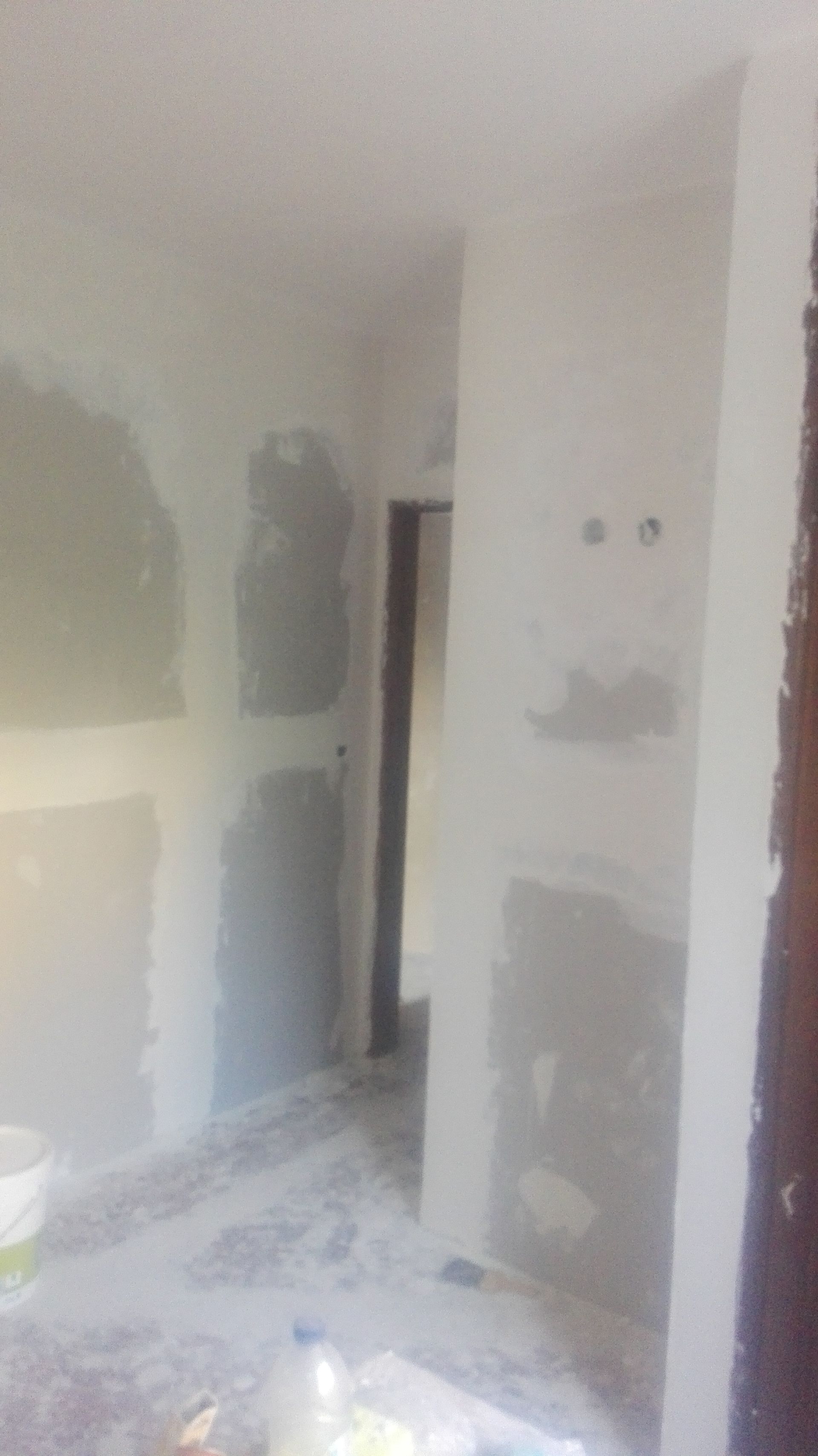 Quarto interior em construção, com drywall, paredes inacabadas e porta.