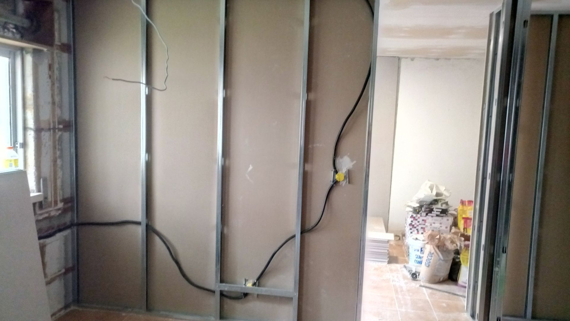 Estrutura interna com drywall parcialmente instalado; fiação elétrica visível.