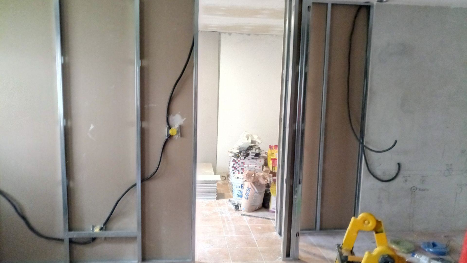 Estrutura interna com drywall parcialmente instalado, fiação elétrica visível.