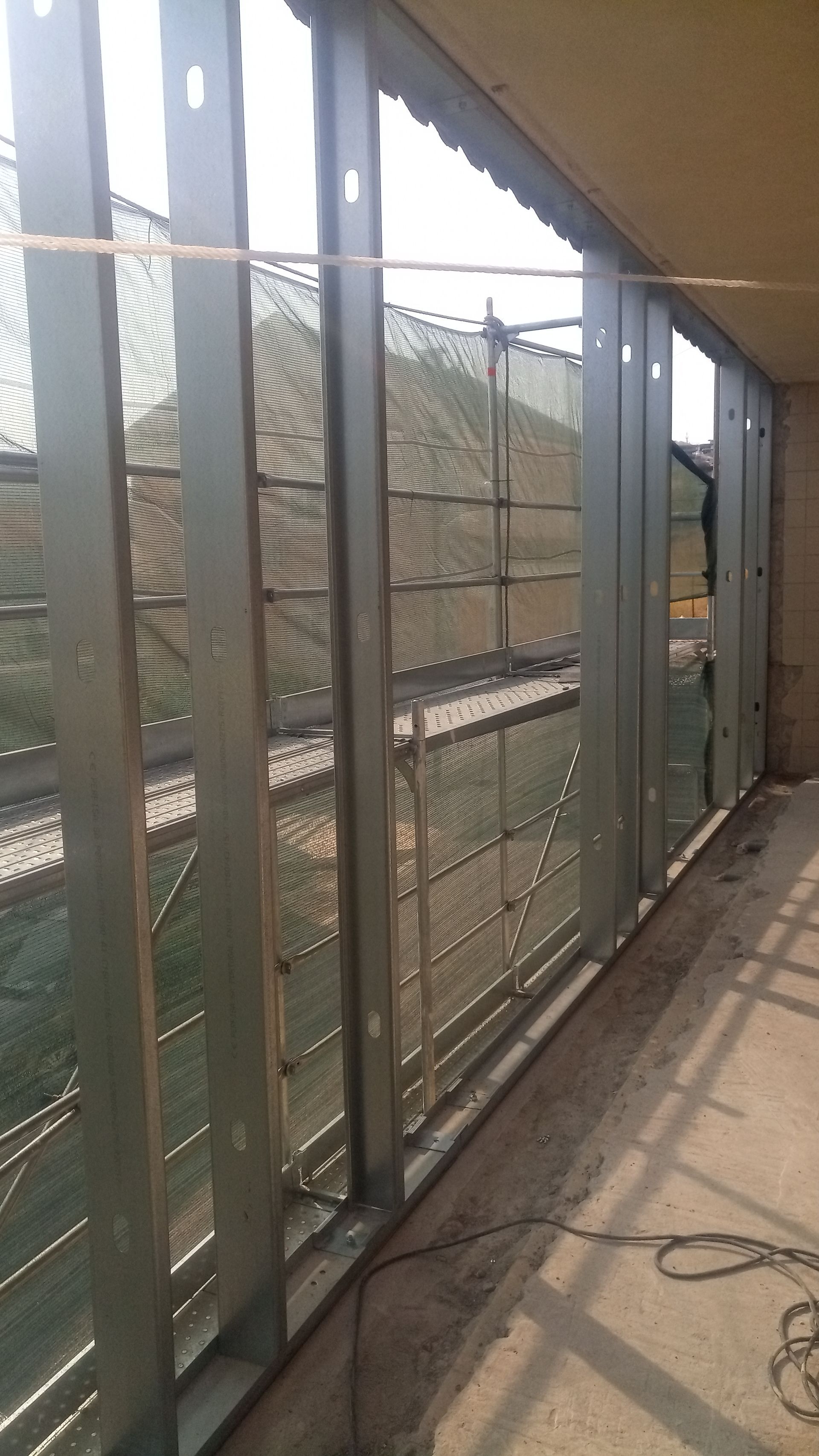 Estrutura metálica instalada, cobrindo parcialmente a abertura, com tela metálica entre as partes.