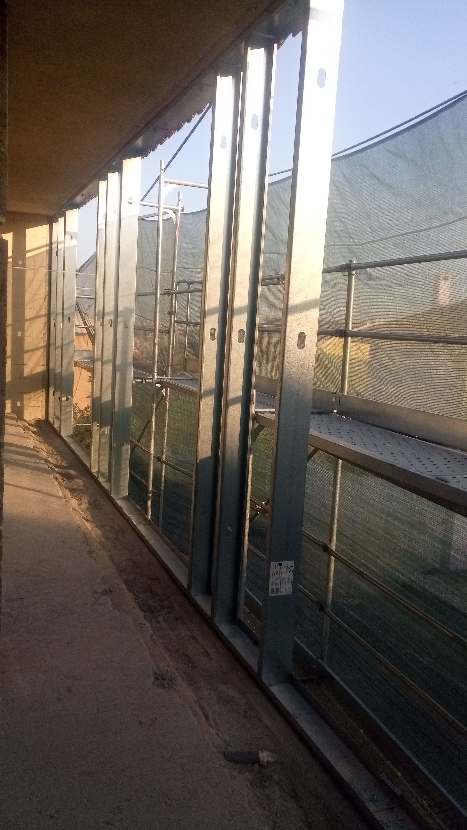 Varanda com estrutura metálica e rede de segurança. Canteiro de obras.