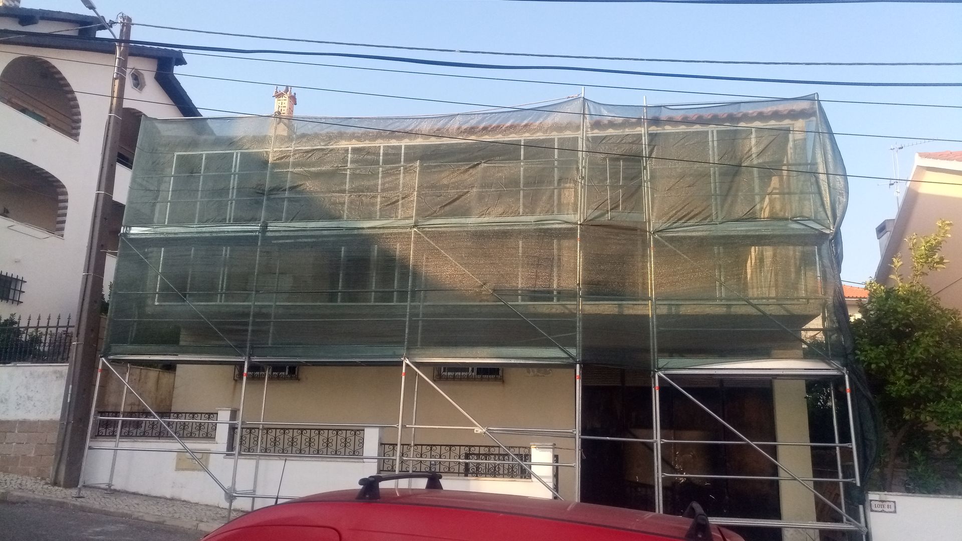 Prédio em reforma, coberto por andaimes e telas de proteção.