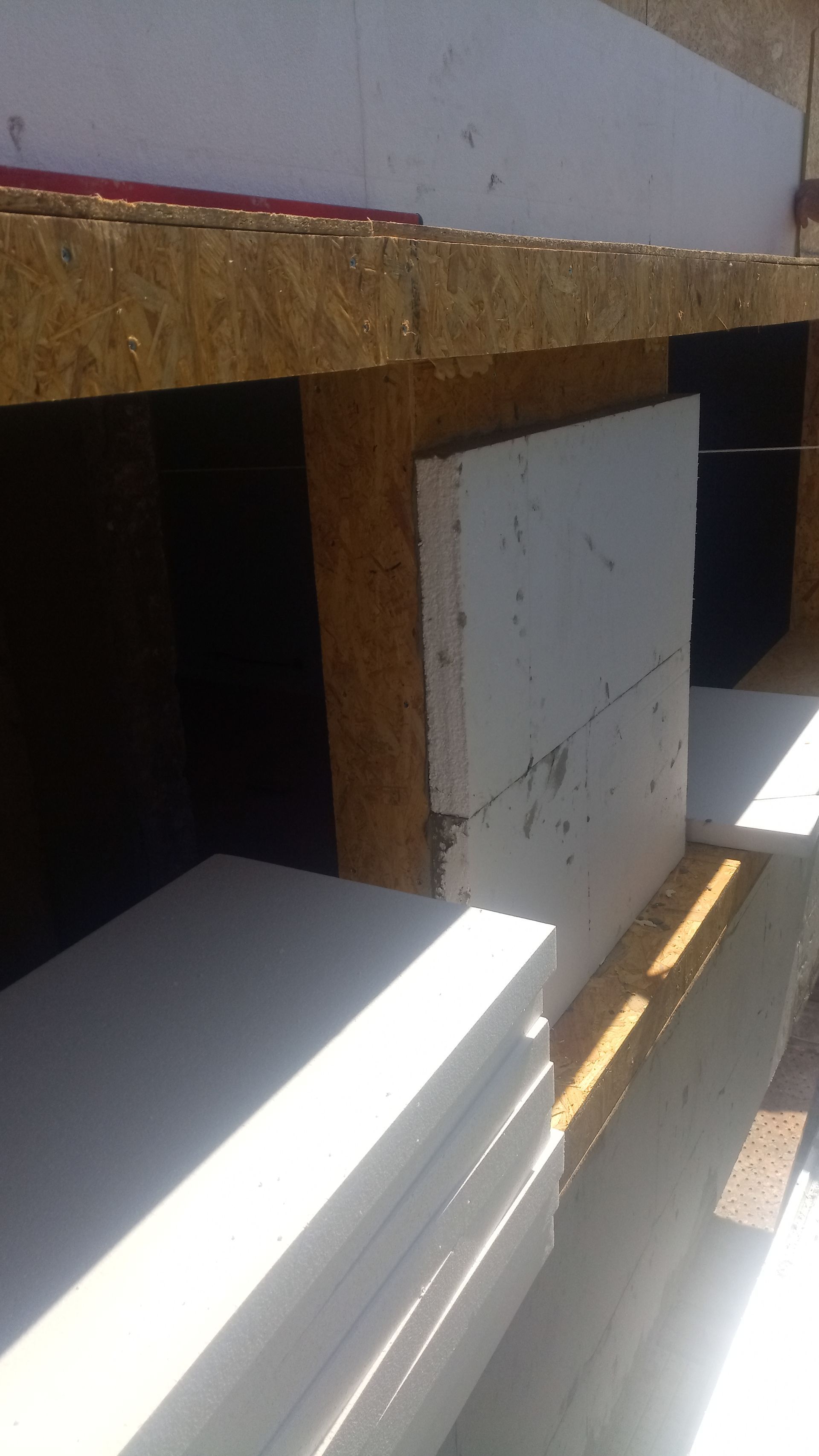 Canteiro de obras: Placas de isolamento de espuma instaladas em estrutura de madeira.