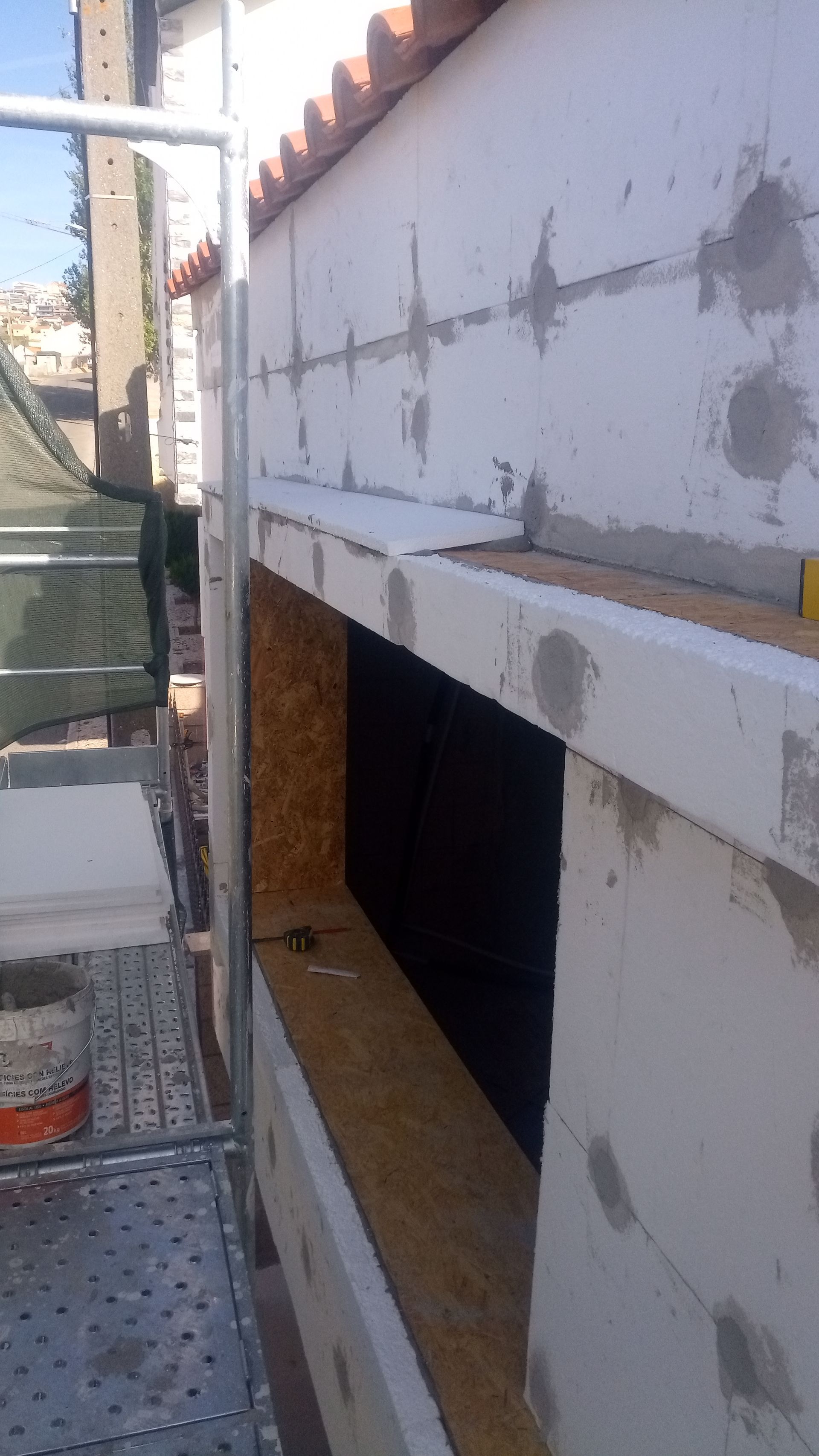 Construção de parede externa com caixilho de janela, andaimes e blocos de espuma.