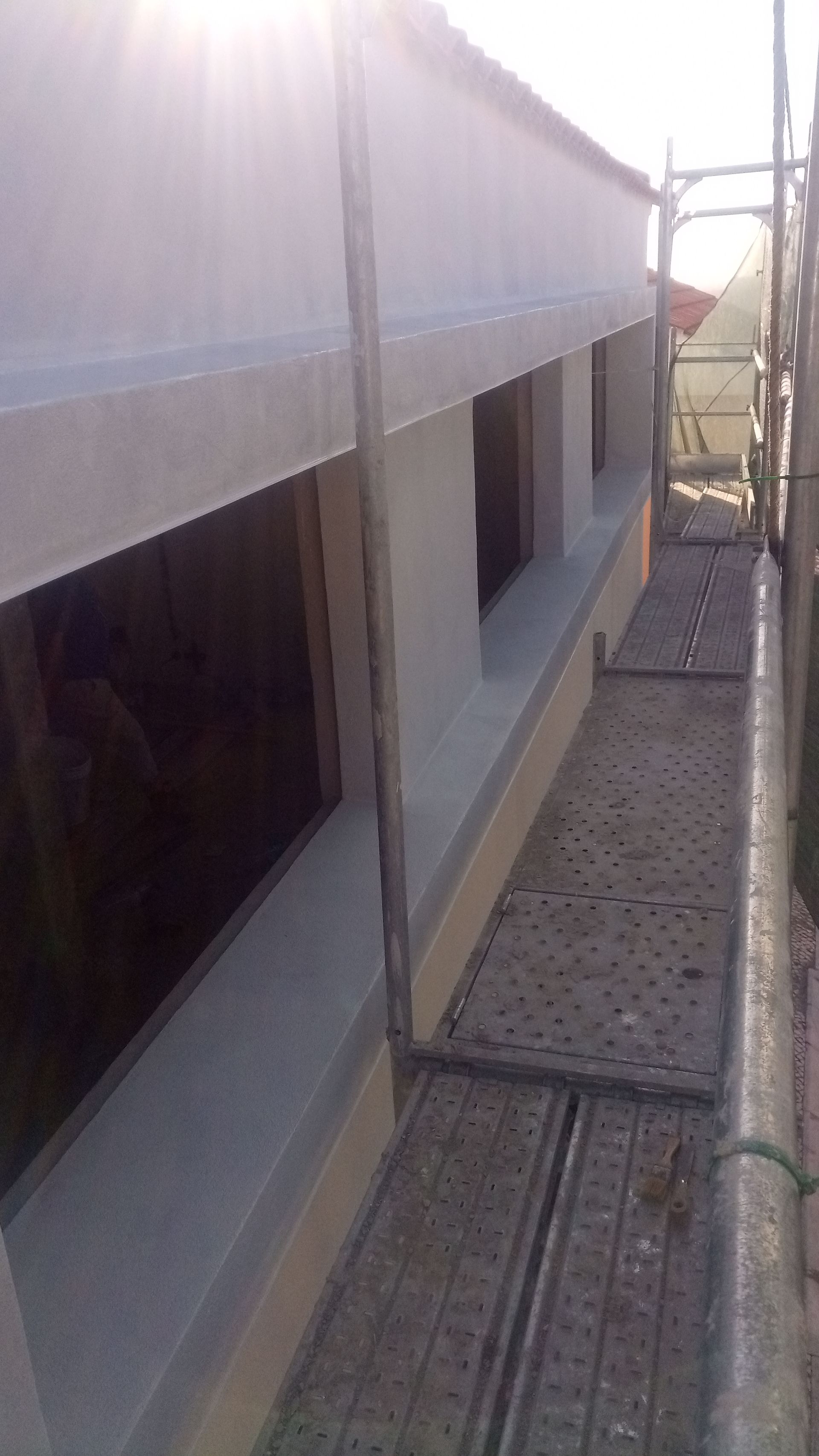 Exterior do edifício com janelas e andaimes.